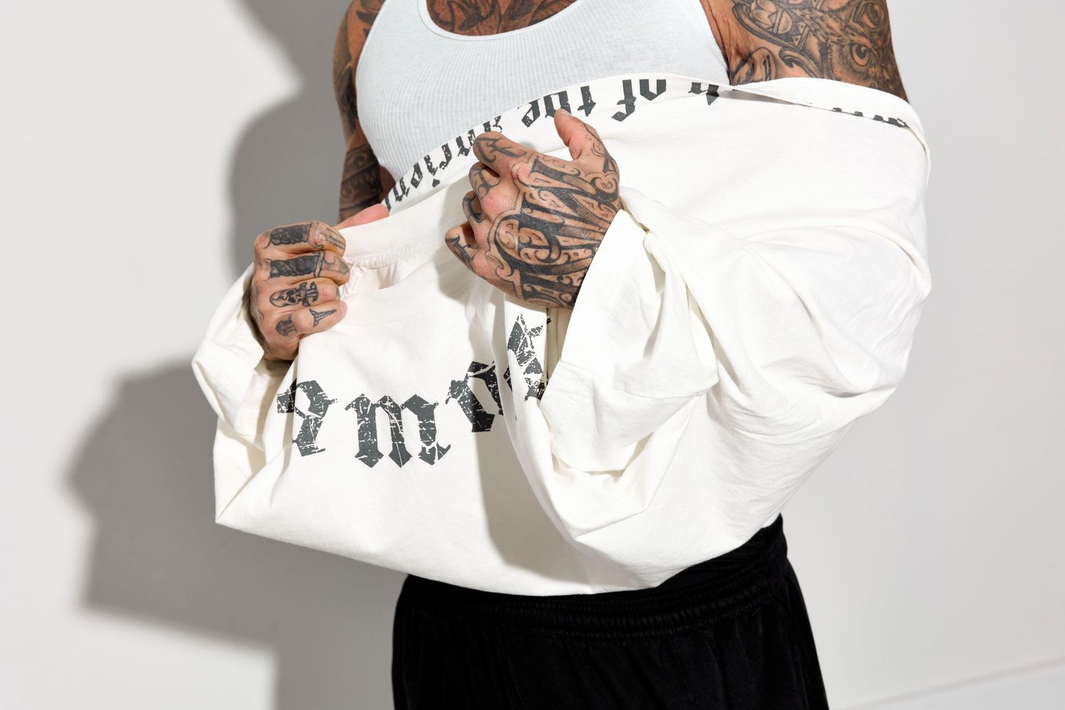 Model showing white t-shirt with gothic lettering design from multiple angles.