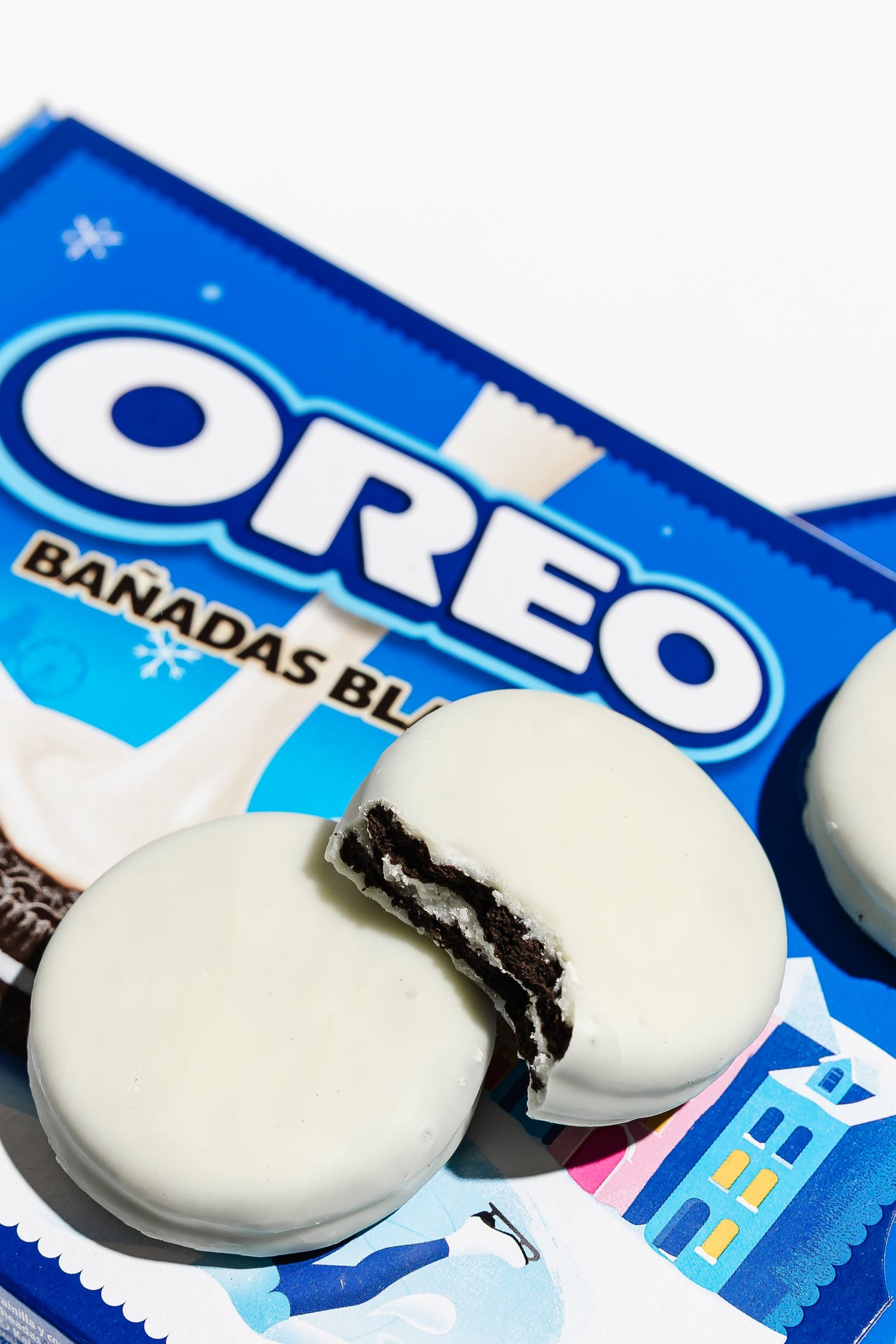 White chocolate covered Oreo cookies displayed with blue packaging.