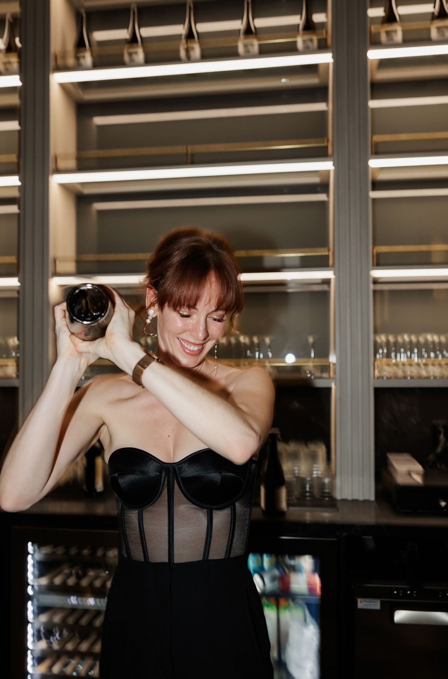 Bartender preparing drinks behind a sleek modern bar counter.