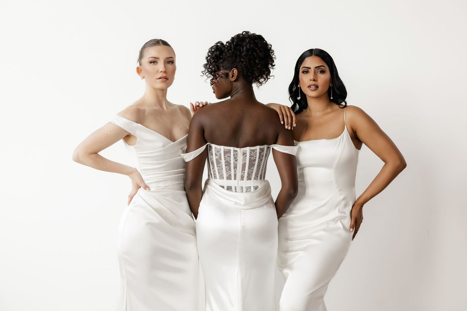 Models showcase diverse bridal styles in modern white wedding dresses against neutral backdrop.