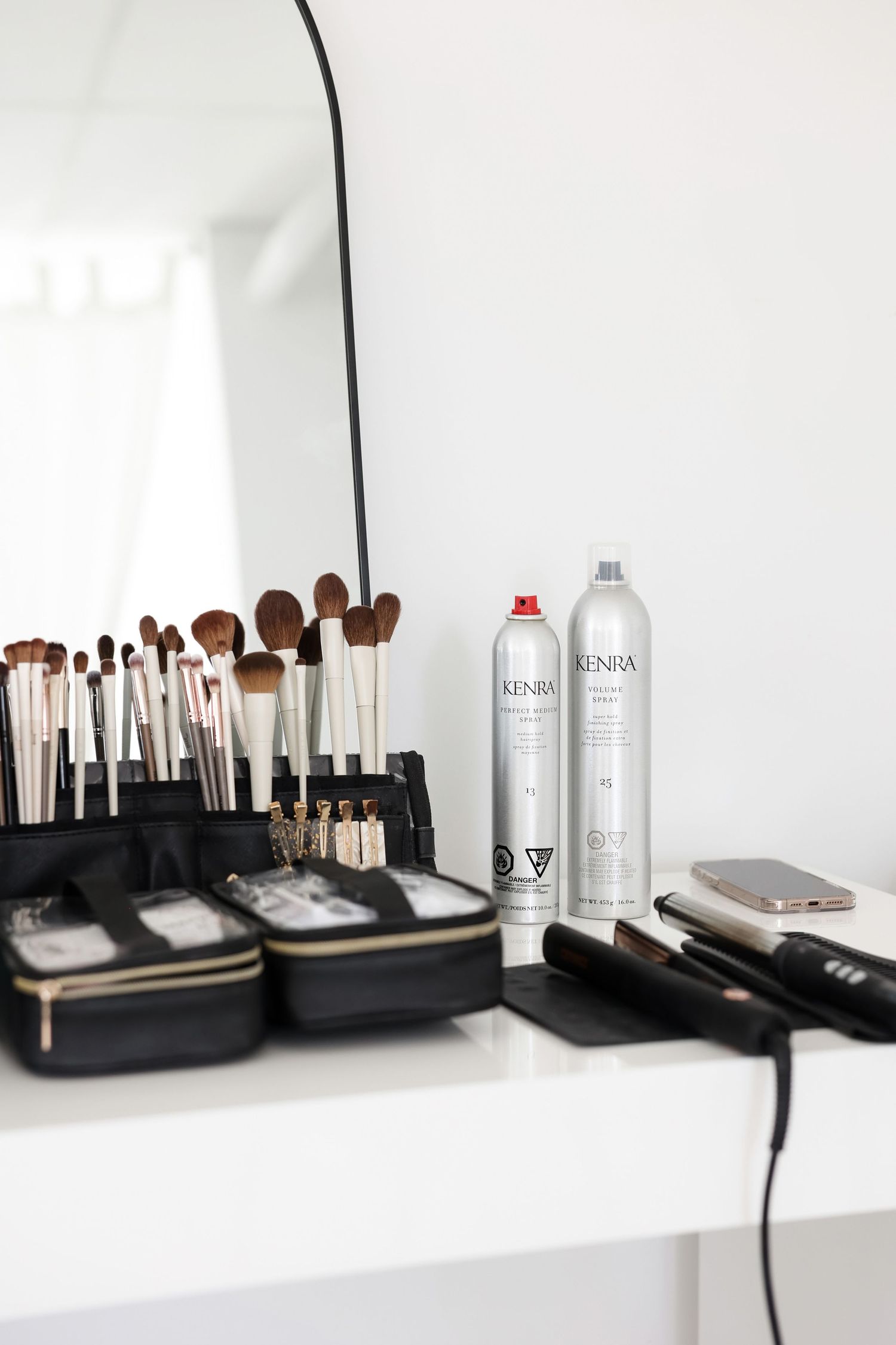 Professional makeup brushes and beauty products arranged neatly on white shelving.
