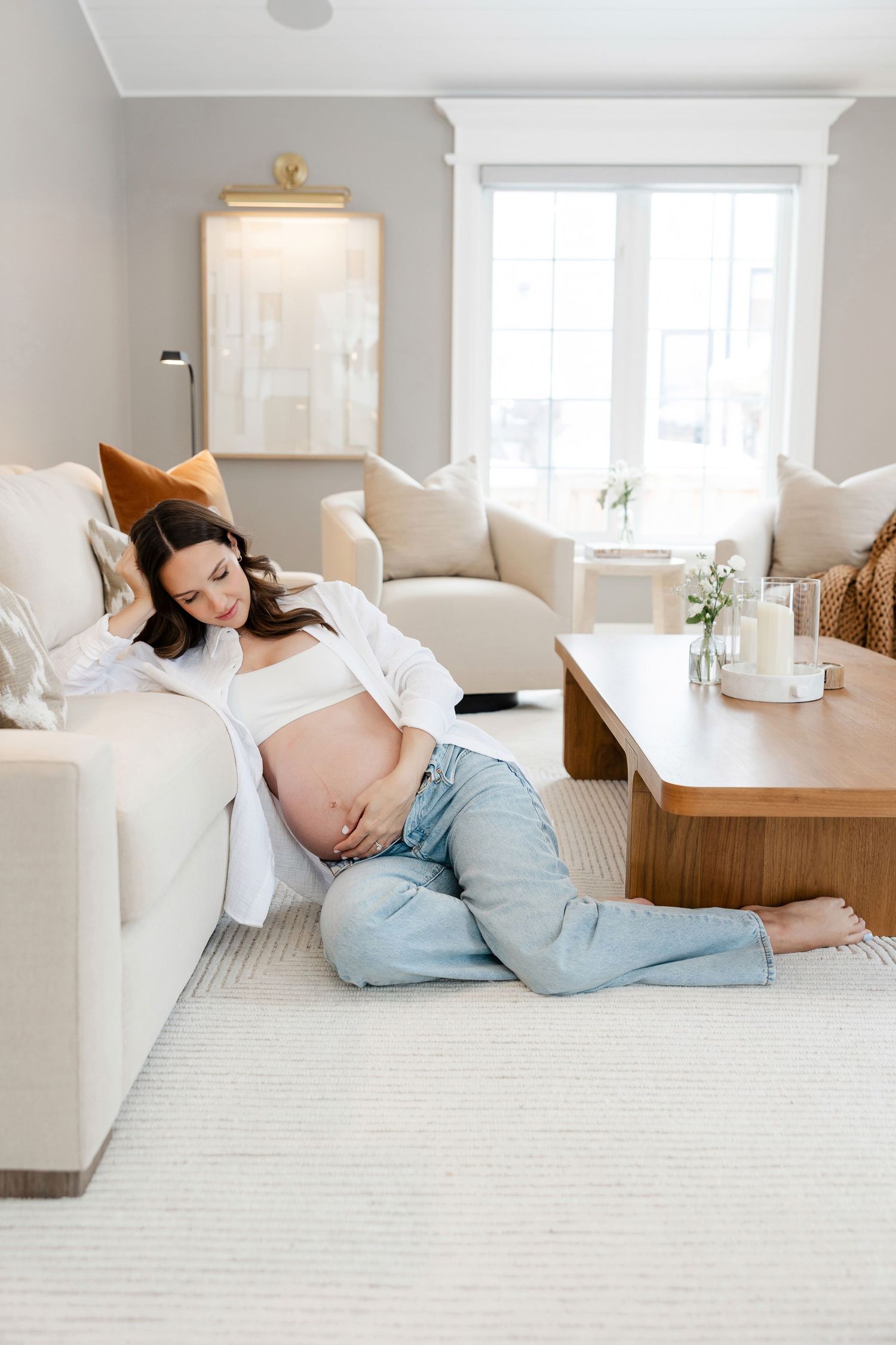 Casual moments captured on white carpet in bright, modern living room.
