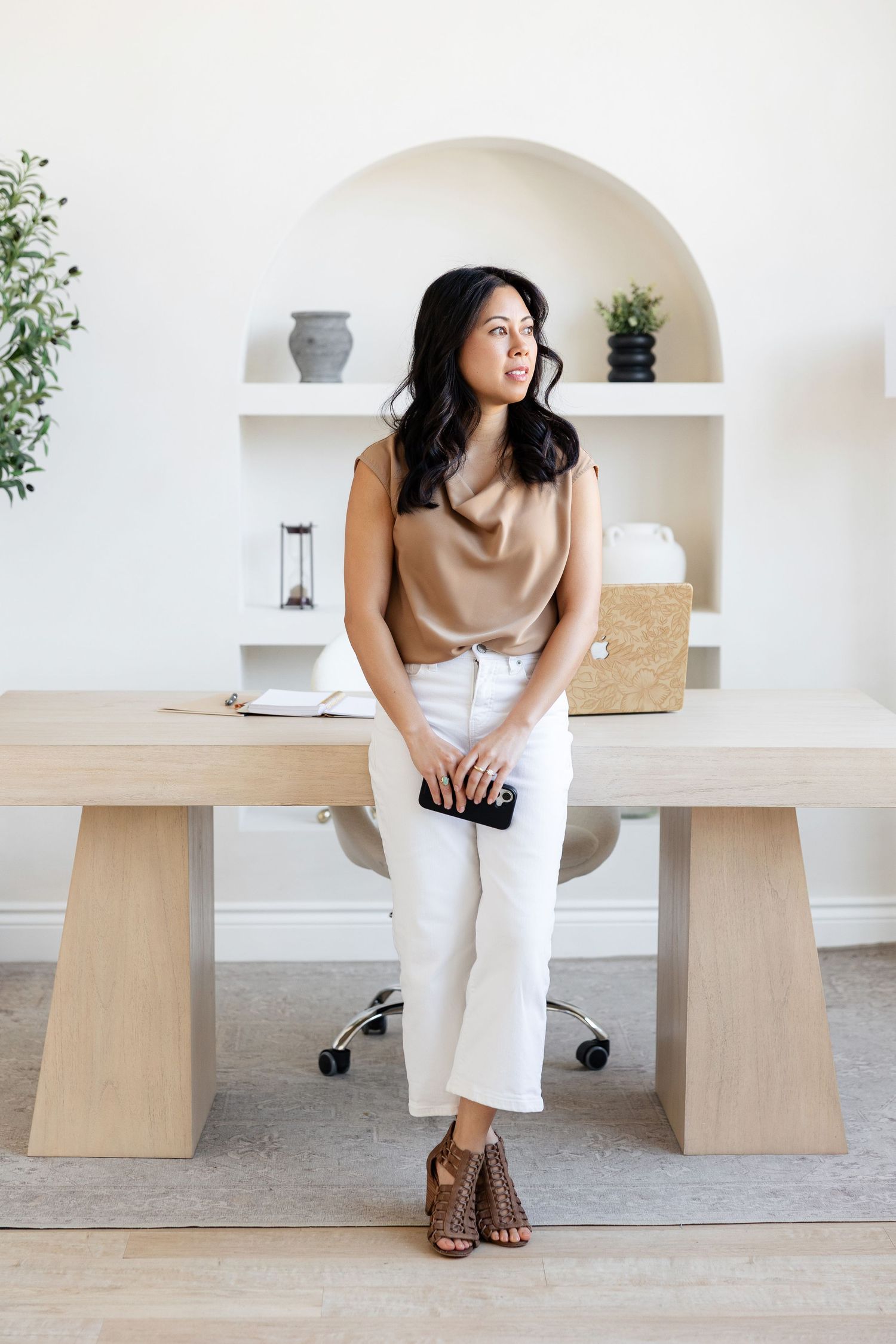 Stylish office setup with tan and white color scheme and minimalist wooden furniture.