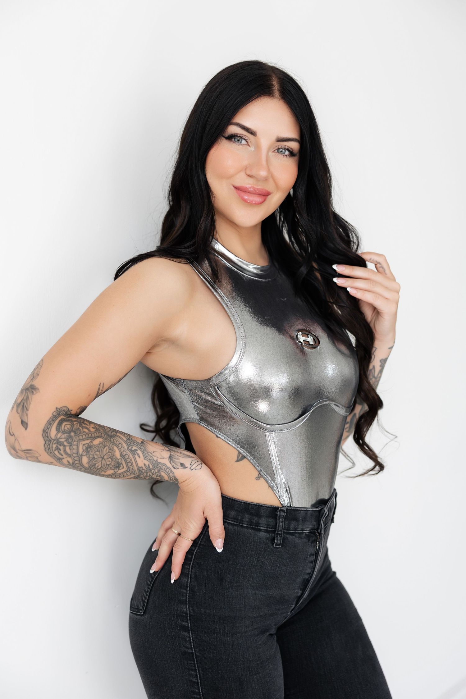 Fashion model in silver metallic top striking dynamic poses against white background.