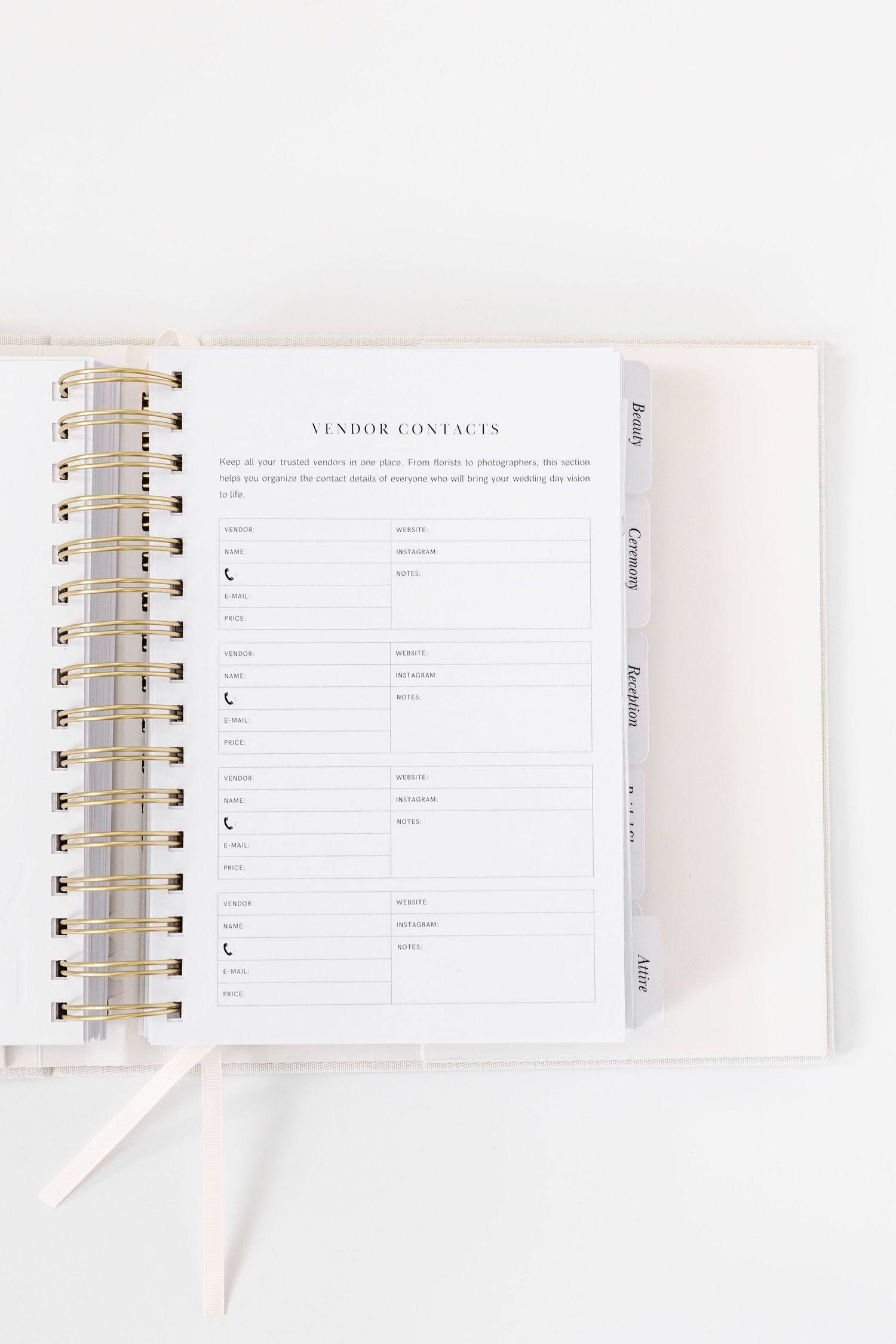 Wedding vendor contact list pages in white spiral-bound planner with minimal design.