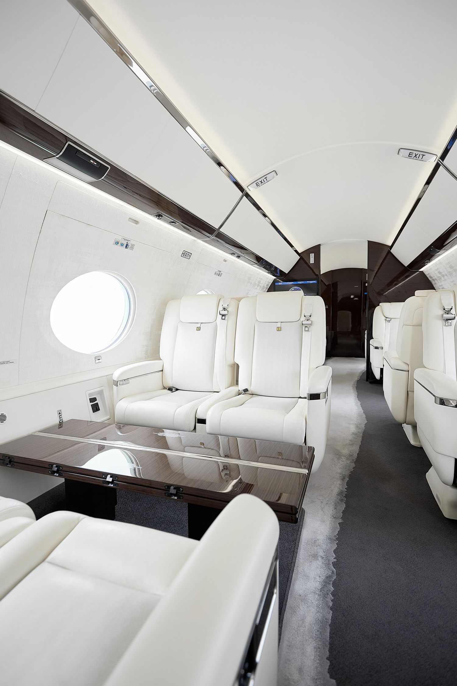 Spacious private jet interior featuring plush white seating and dark carpeting.