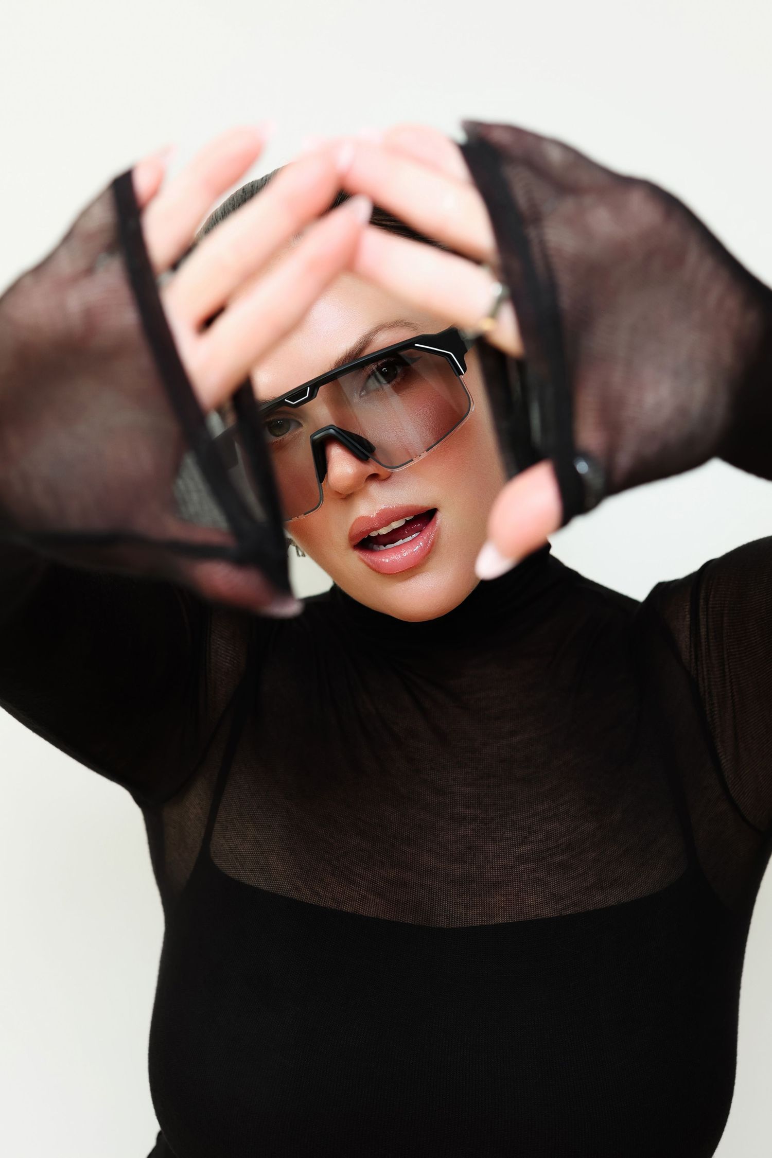 Fashion model wearing black turtleneck and stylish sunglasses in artistic portrait series.