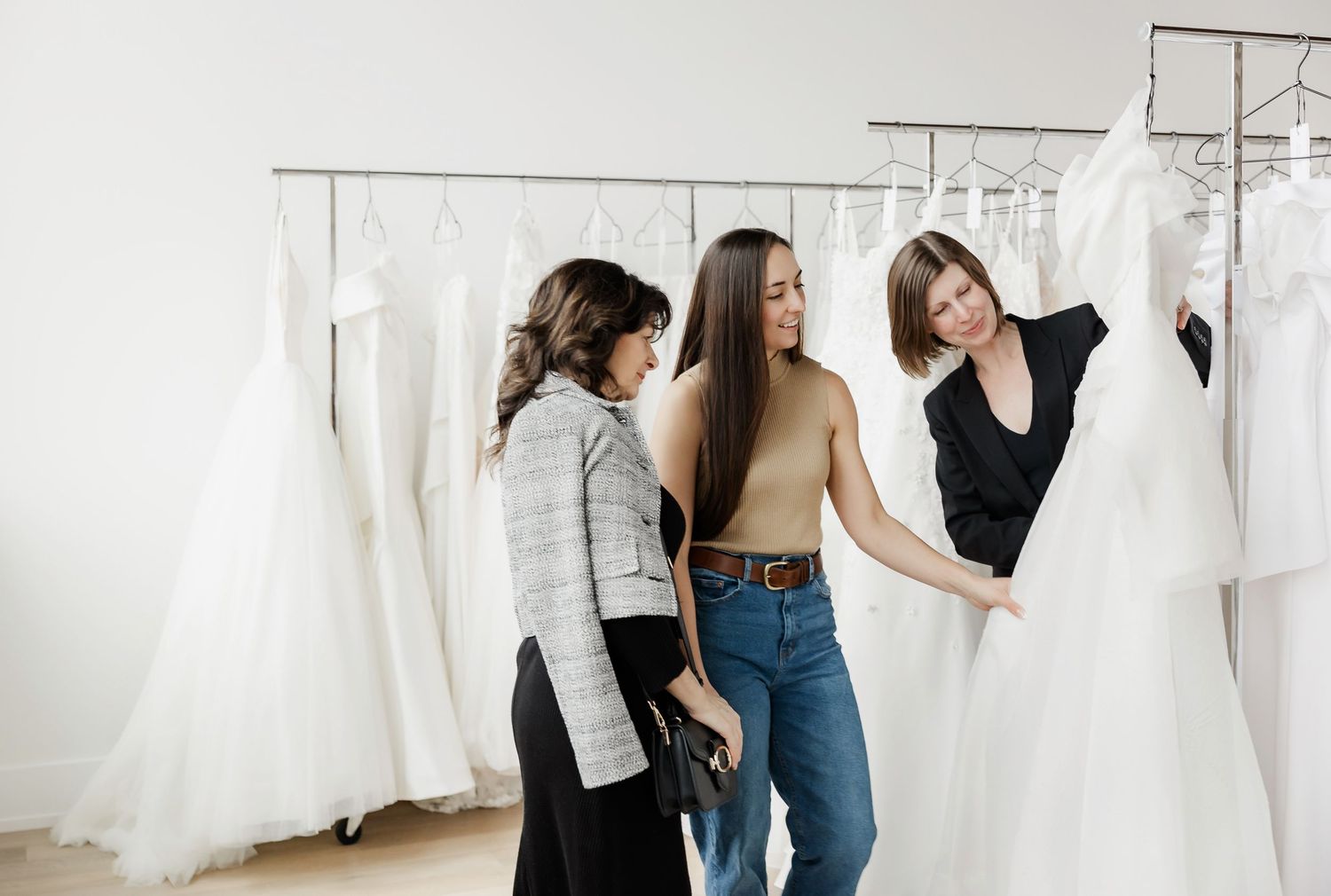 Friends shopping for wedding dresses in a bright, contemporary bridal salon.