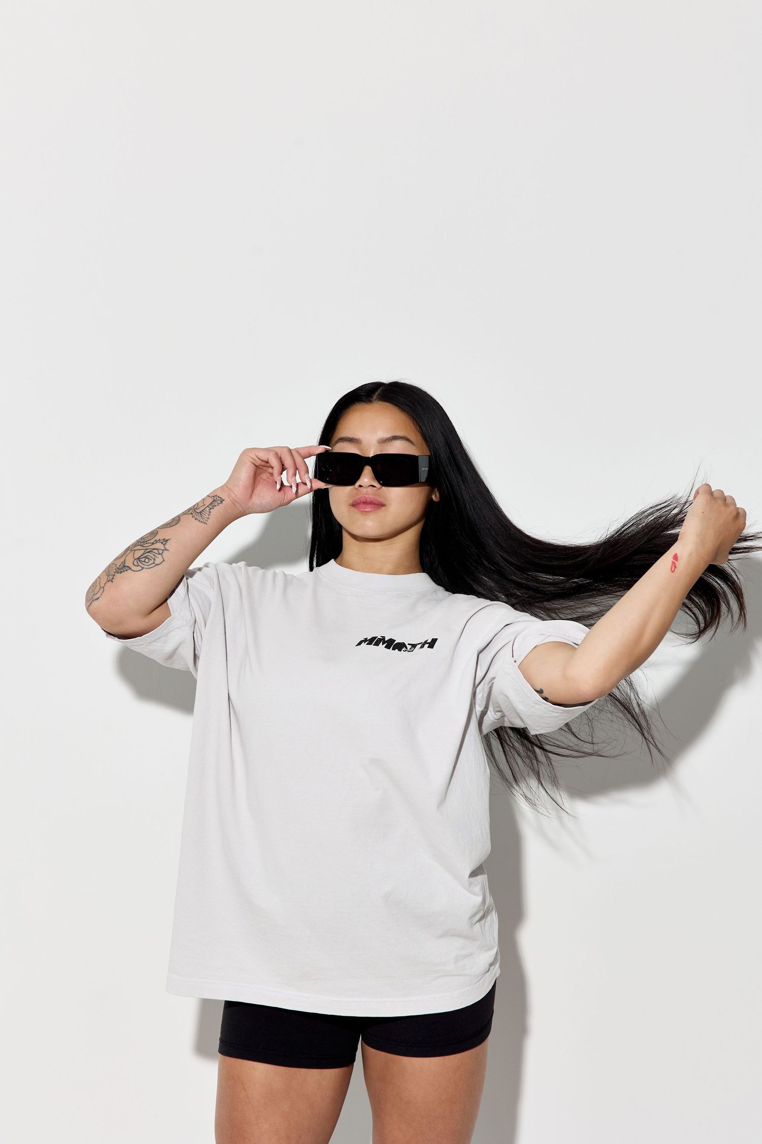Model in white Mammoth shirt and black shorts poses dynamically against white backdrop.