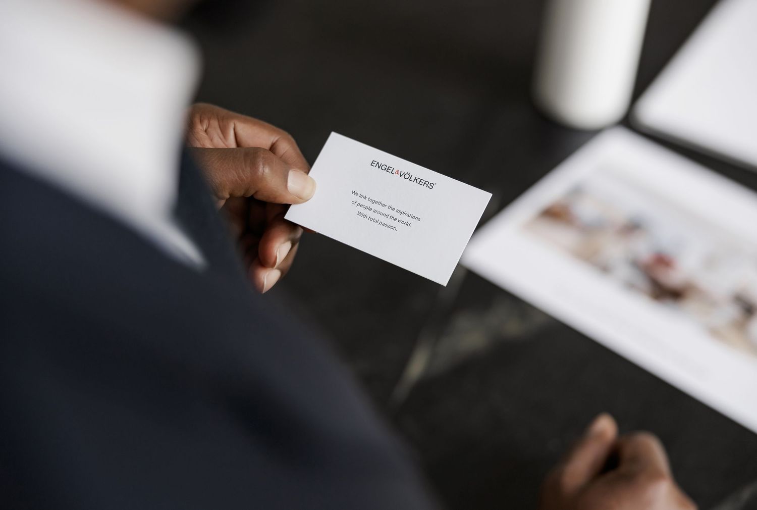 Close-up view of hands holding business documents in a modern office setting.