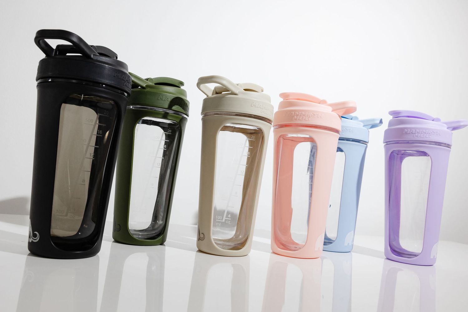 Row of minimalist water bottles in various colors displayed against white background.
