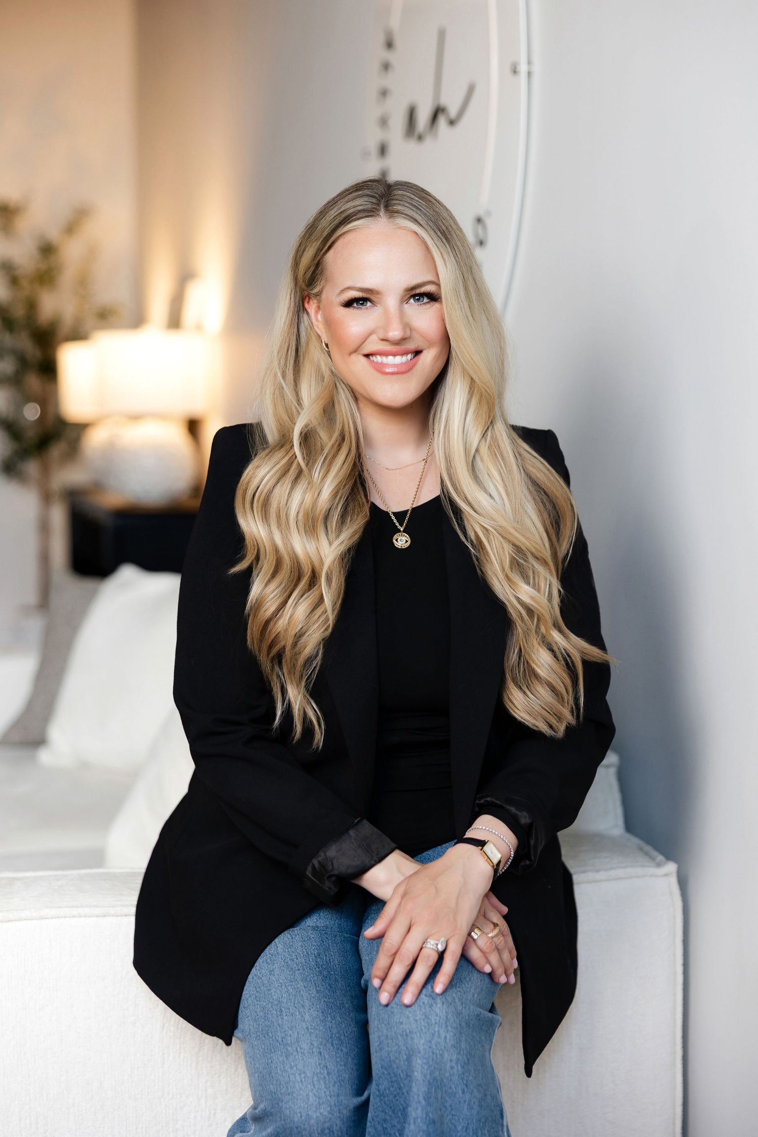 Professional studio portraits featuring black blazer and denim in a bright interior setting.