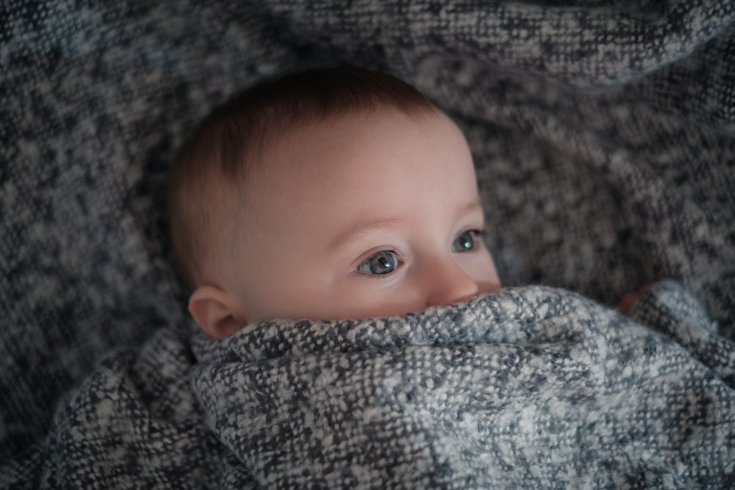 Newborn, baby wrapped in soft blanket during an at-home photography session in Slaithwaite, Huddersfiled, West Yorkshire