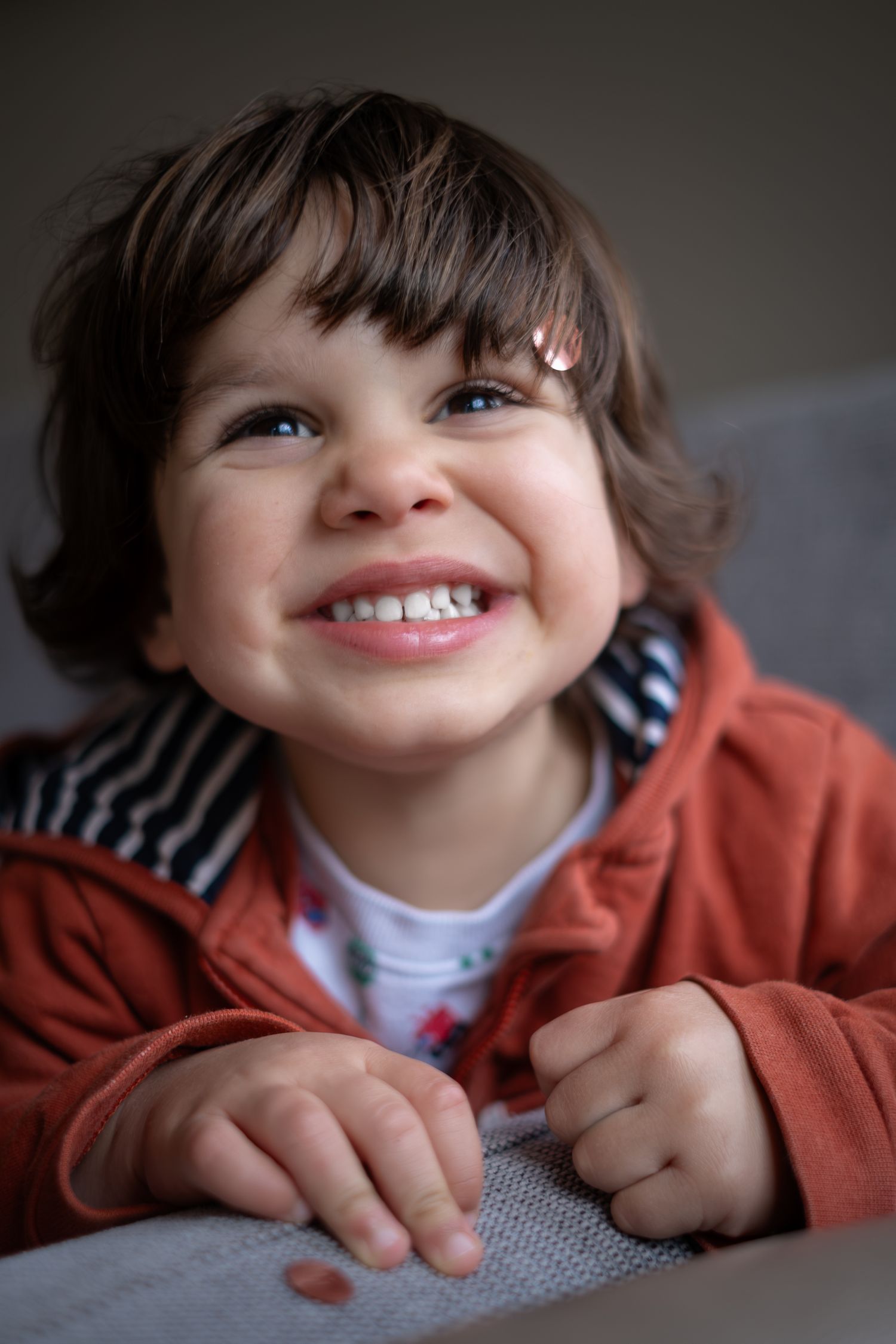 Boy smiling with cheeky smile looking into camera