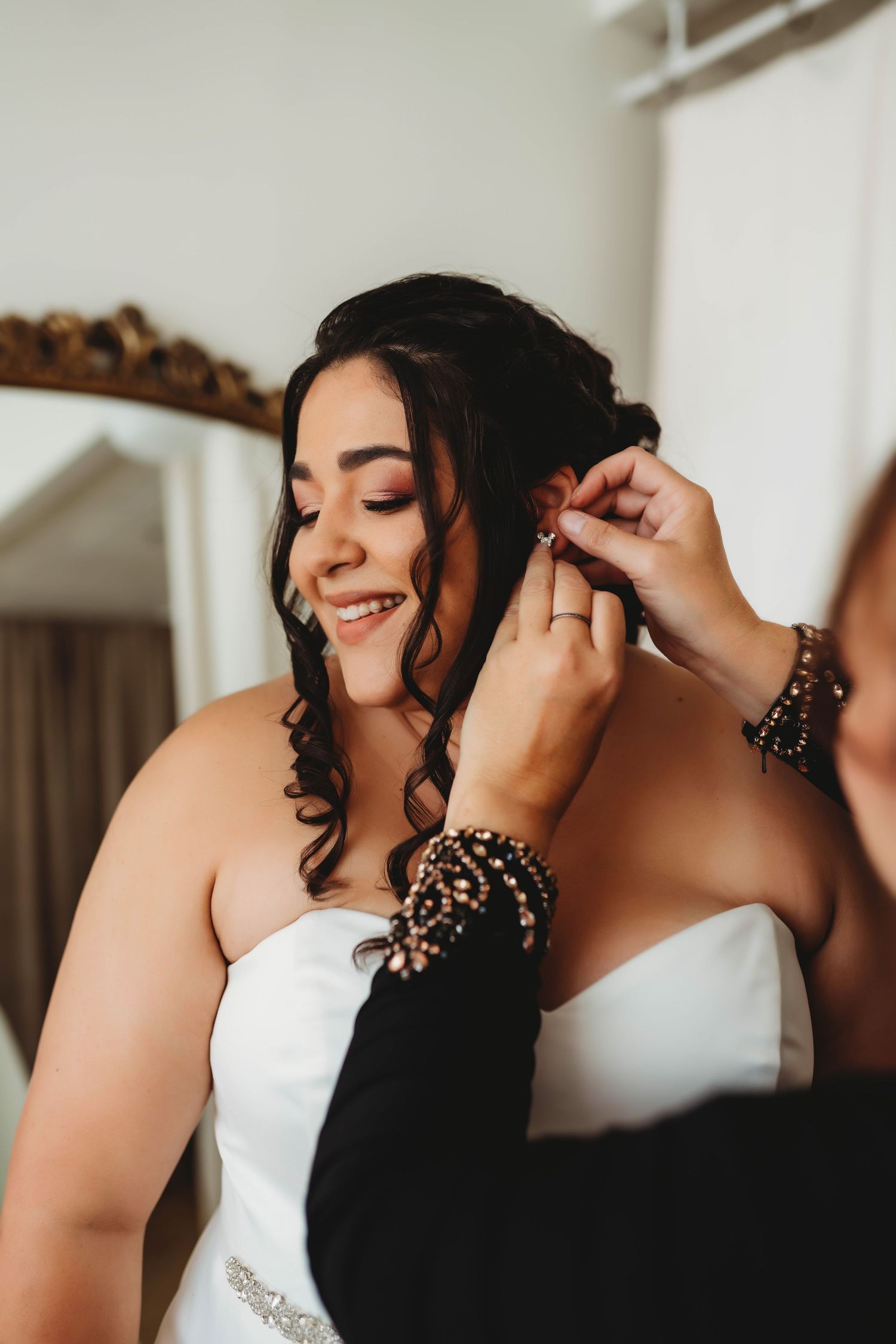 Getting ready scene with white wedding dress and black lace details in morning light.