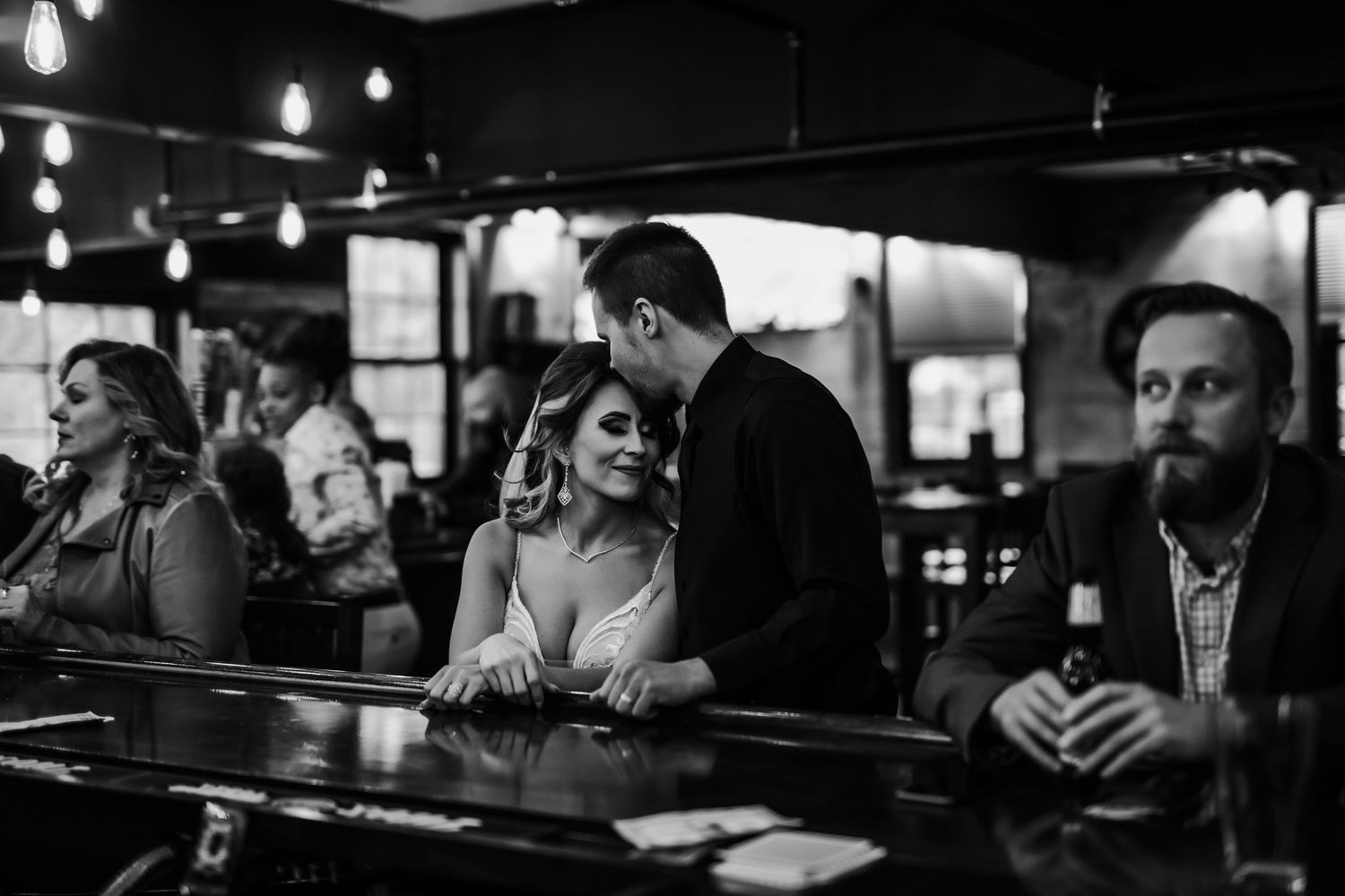 Wedding couple sitting at a bar enjoying conversation and drinks.