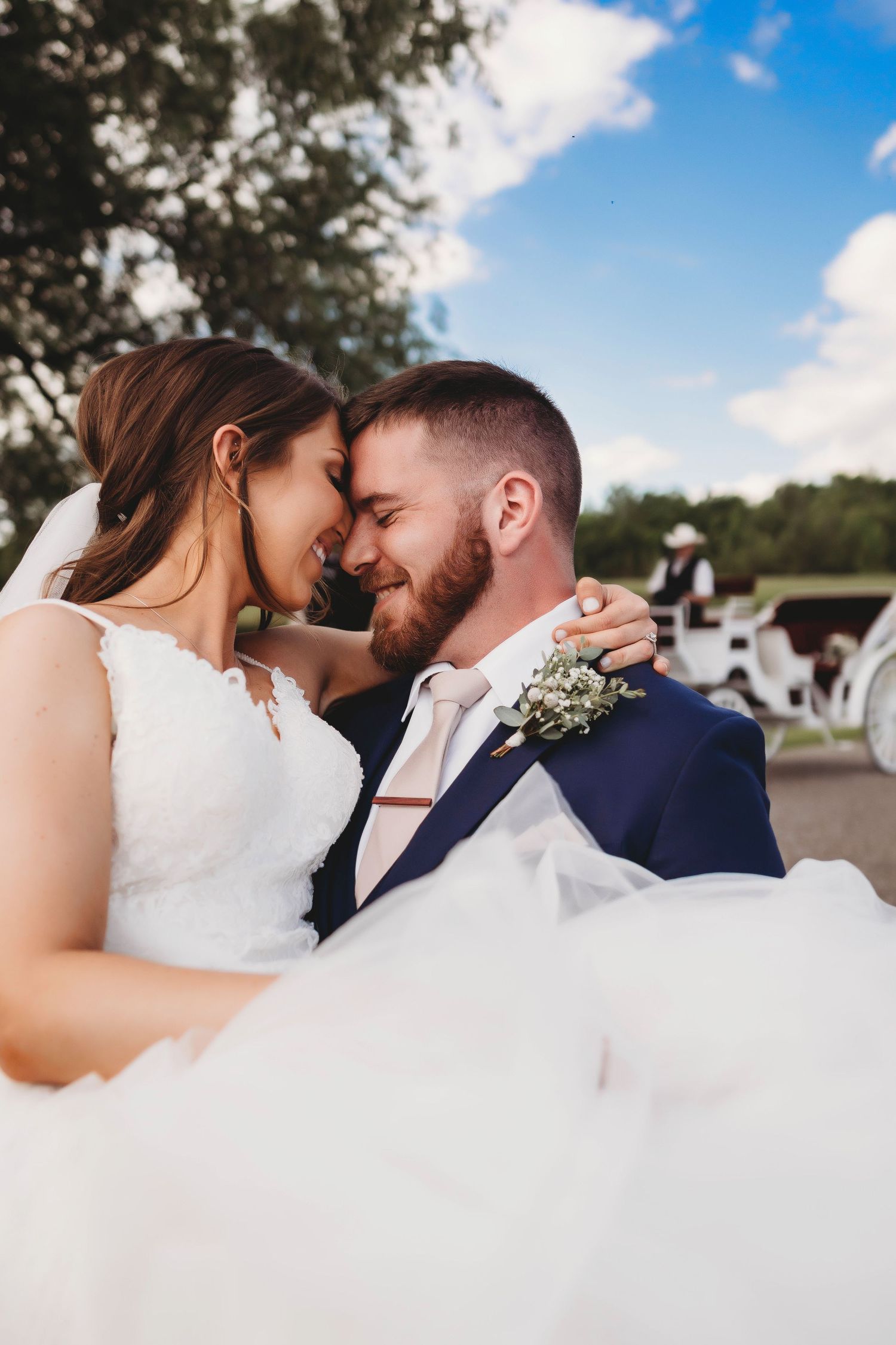 Romantic wedding couple embracing outdoors under blue skies, captured in a timeless and emotional wedding photography style.