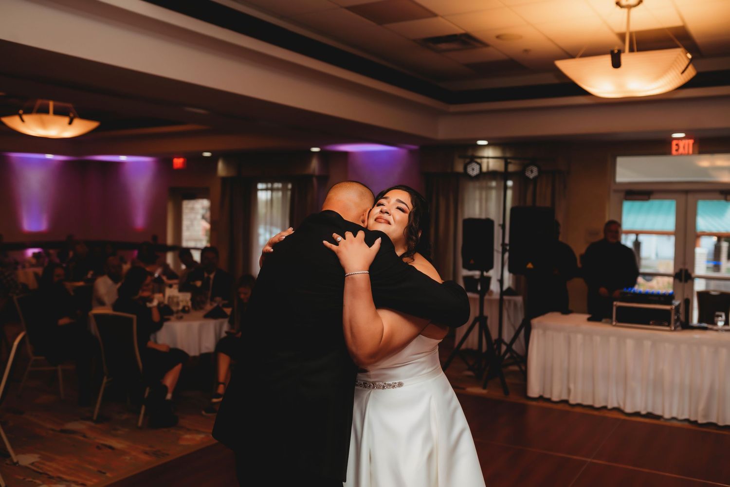 Wedding reception moment with the bride and her father, captured in a candid documentary style.
