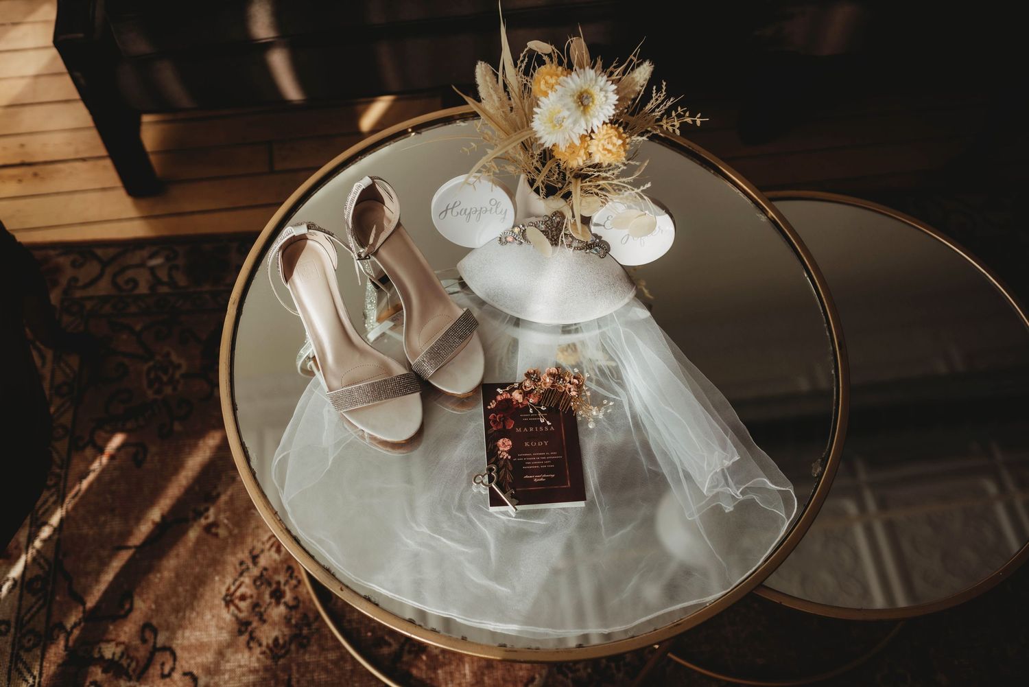 Wedding details with delicate glassware and decorative elements in warm lighting.