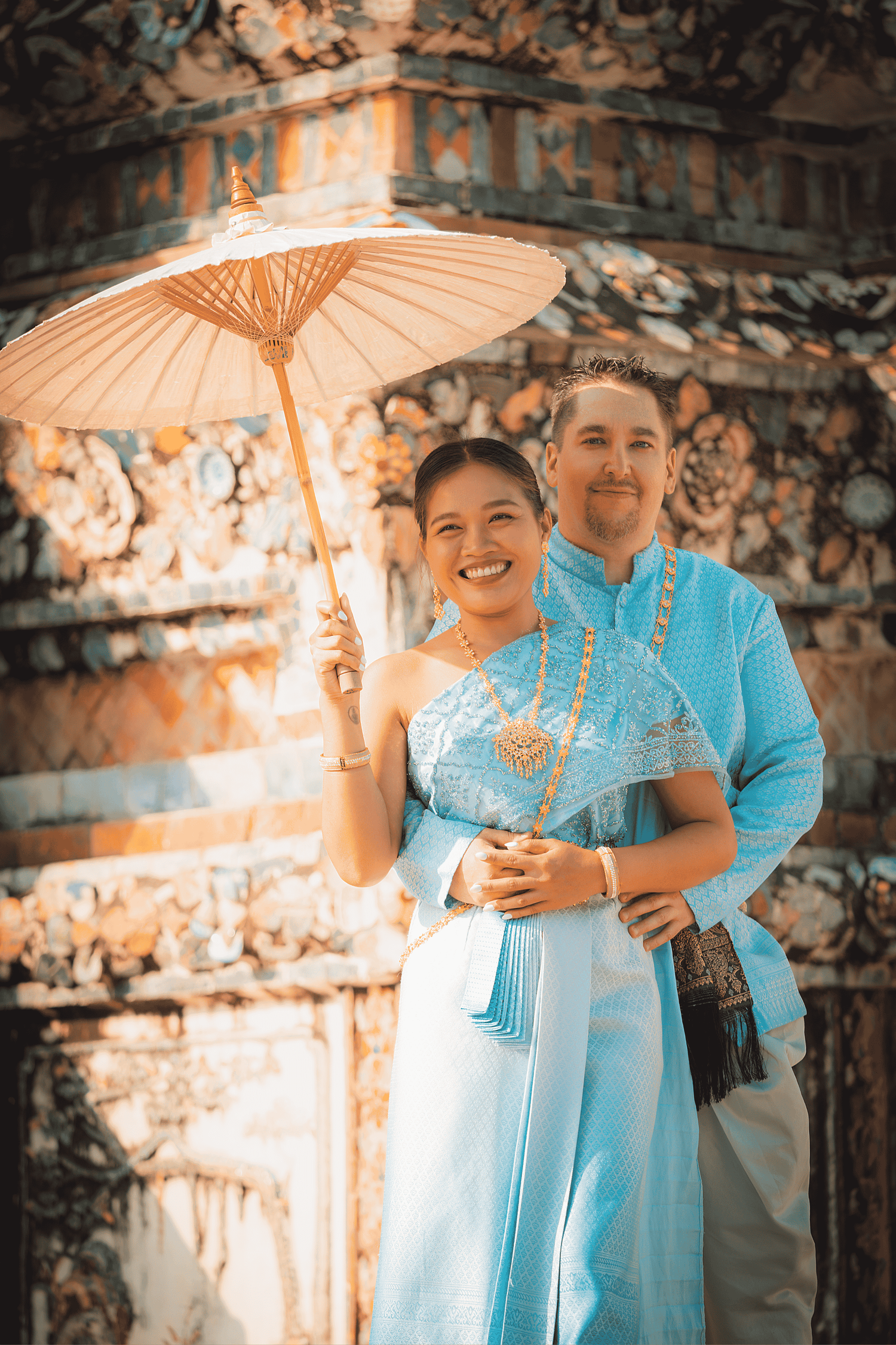 Couple portrait session in Bangkok featuring a smiling couple standing beneath an illuminated archway during an outdoor lifestyle photoshoot