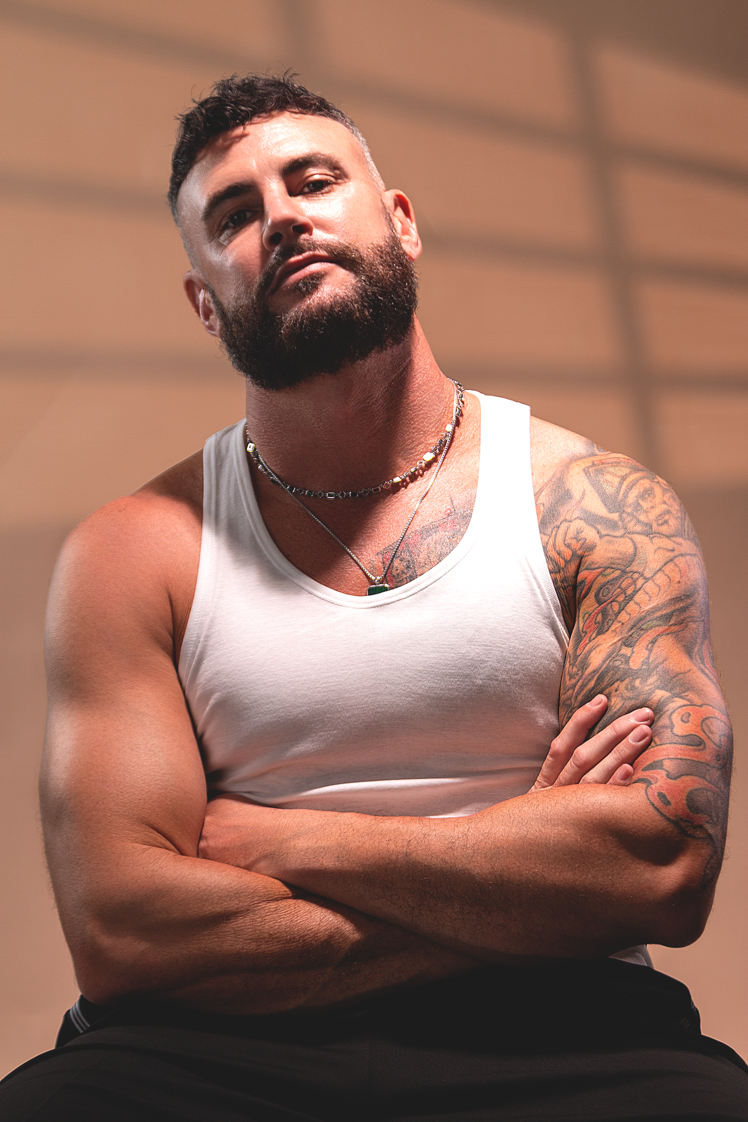 Personal branding portrait featuring a tattooed male model photographed with warm studio lighting.