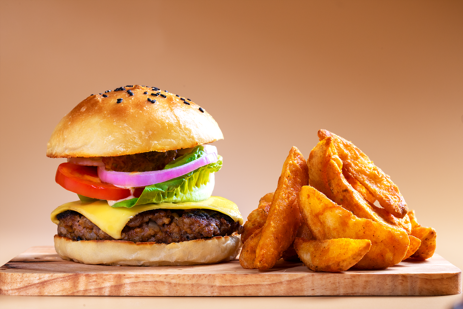 Commercial burger photography featuring a gourmet burger and potato wedges styled for restaurant advertising and menu promotion.
