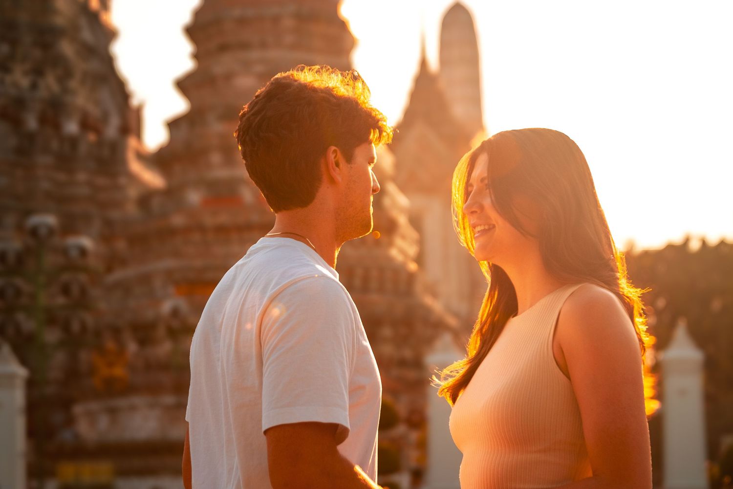 Couples photography in Bangkok featuring a romantic outdoor portrait captured during golden hour at a historic location.