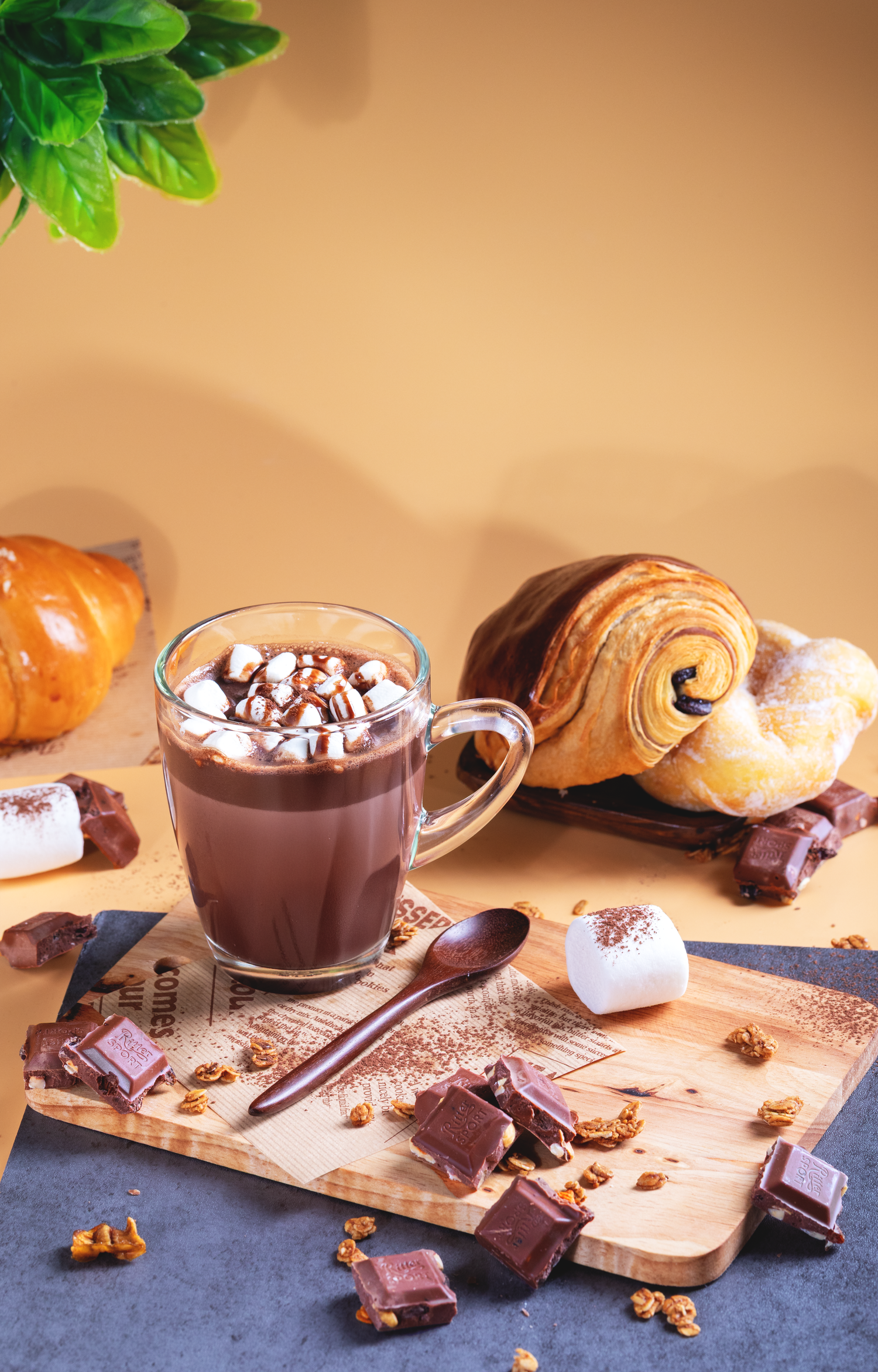 Commercial café photography showcasing hot chocolate, croissants, and baked goods for restaurant advertising and social media promotion.