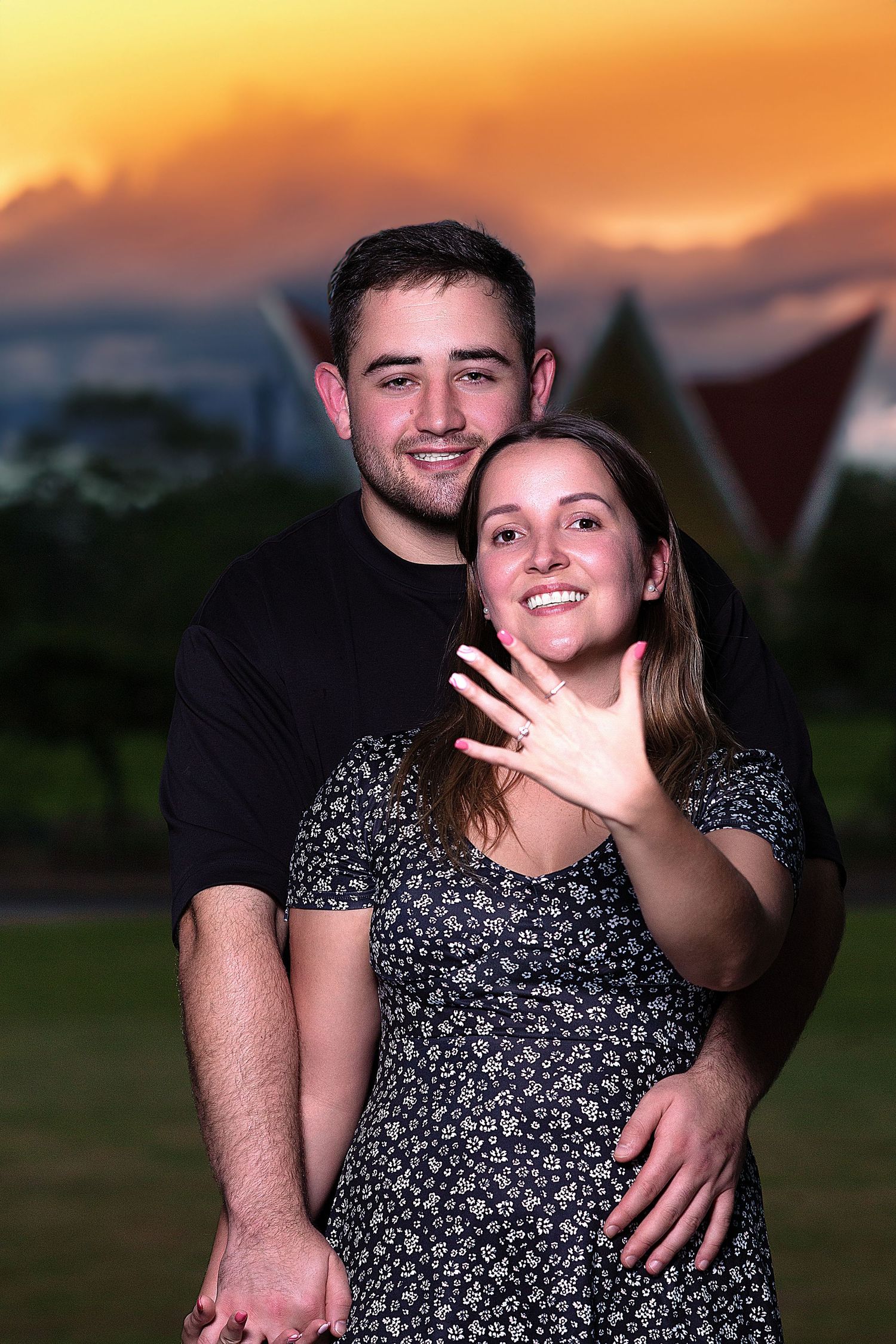 Outdoor couples portrait photography featuring a smiling couple captured during golden hour with a scenic sunset backdrop.