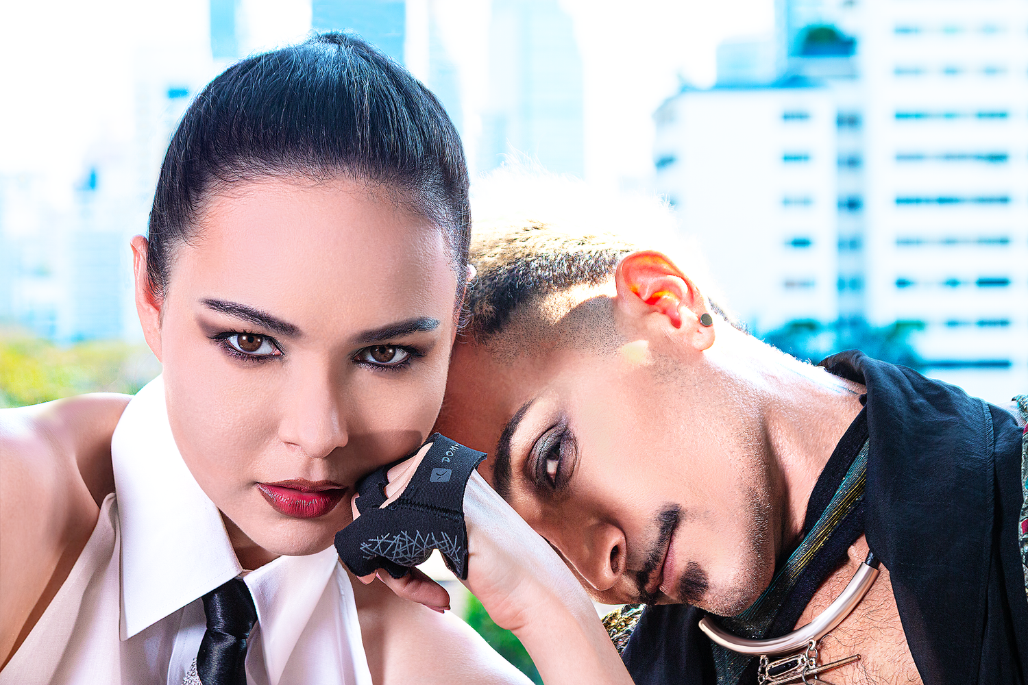 Editorial fashion portrait featuring two models captured in a contemporary urban setting with dramatic styling.