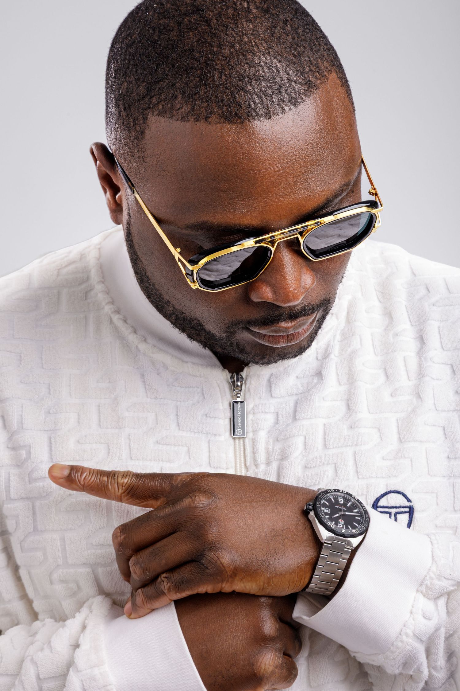 Studio portrait of a male artist wearing sunglasses photographed in Bangkok with clean professional lighting.
