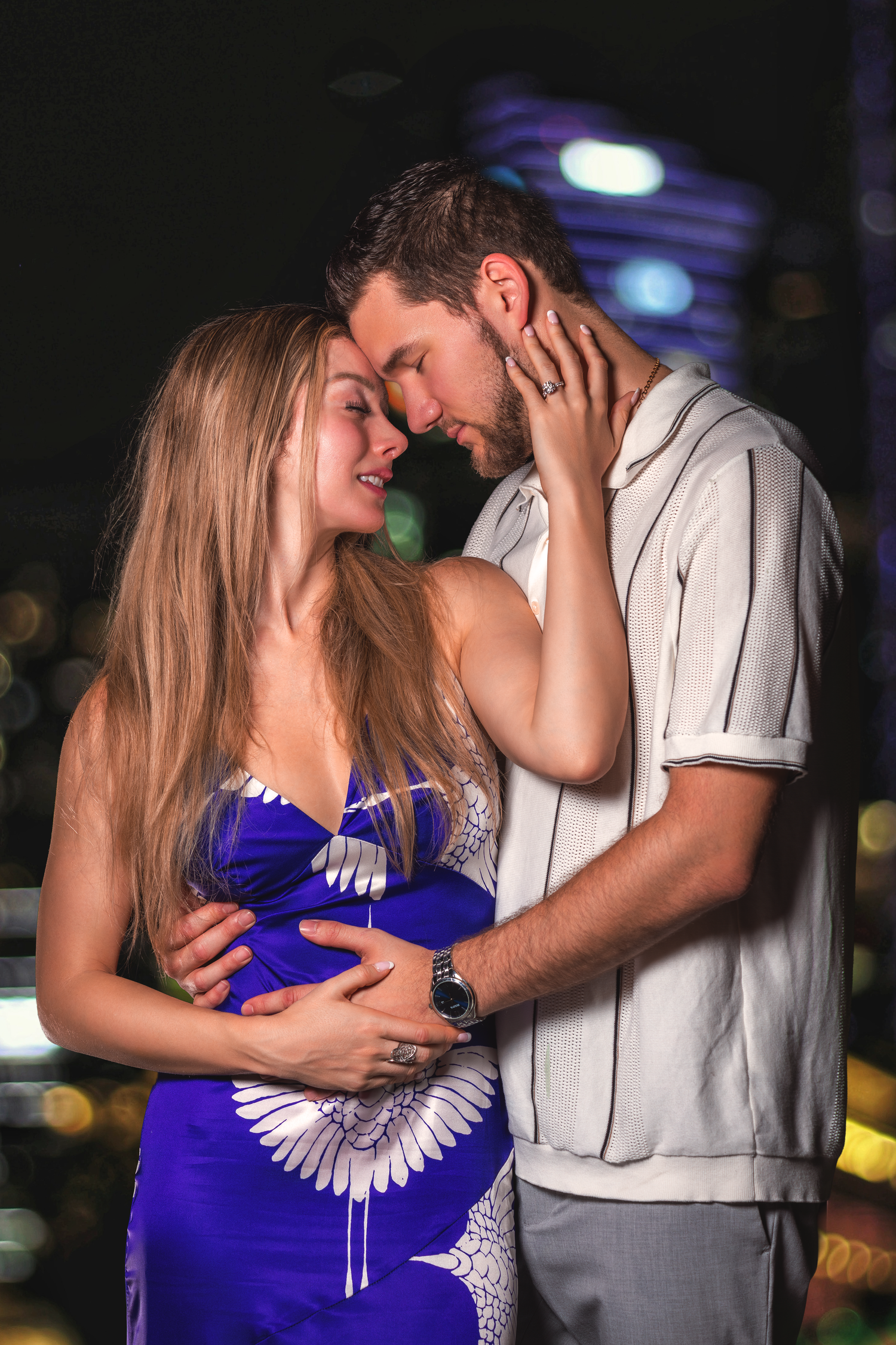 Romantic couple portrait photographed at night with cinematic lighting and natural interaction.