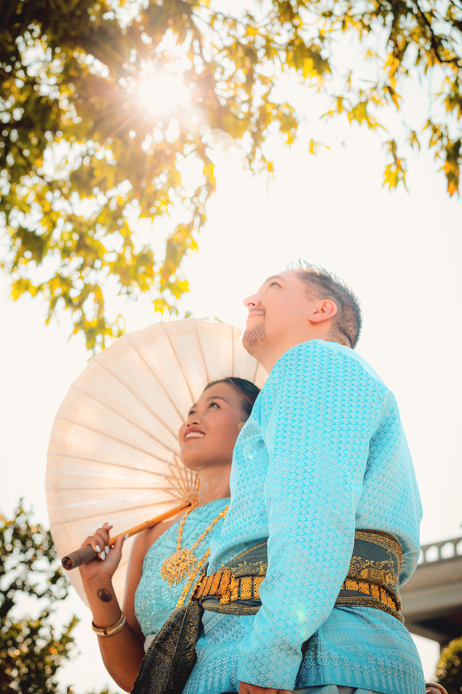 Couples portrait photography featuring a couple embracing beneath natural sunlight at Wat Arun, Bangkok.