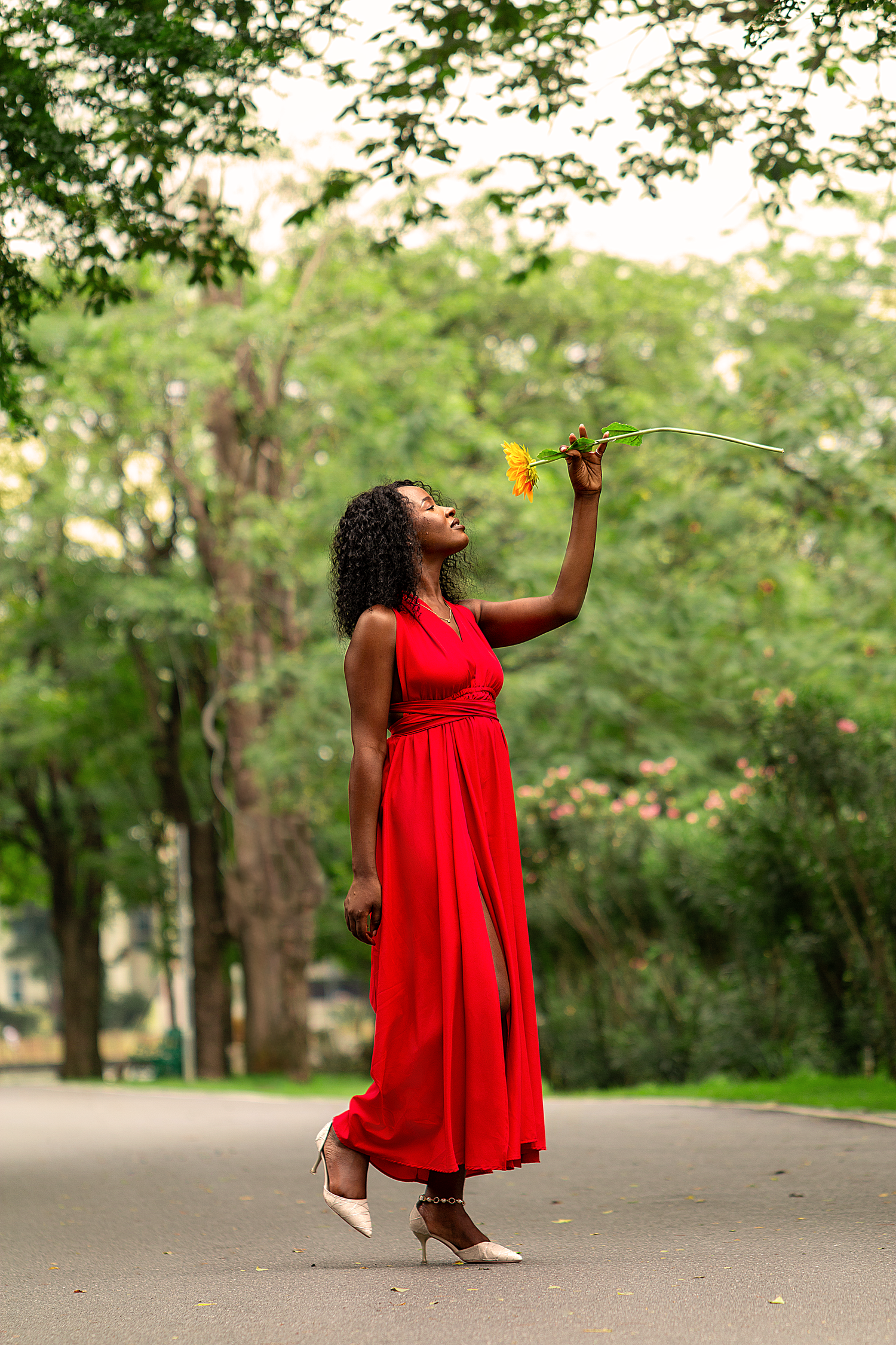 Outdoor lifestyle portrait photography featuring a woman in a flowing red dress captured in a natural park setting in Bangkok.