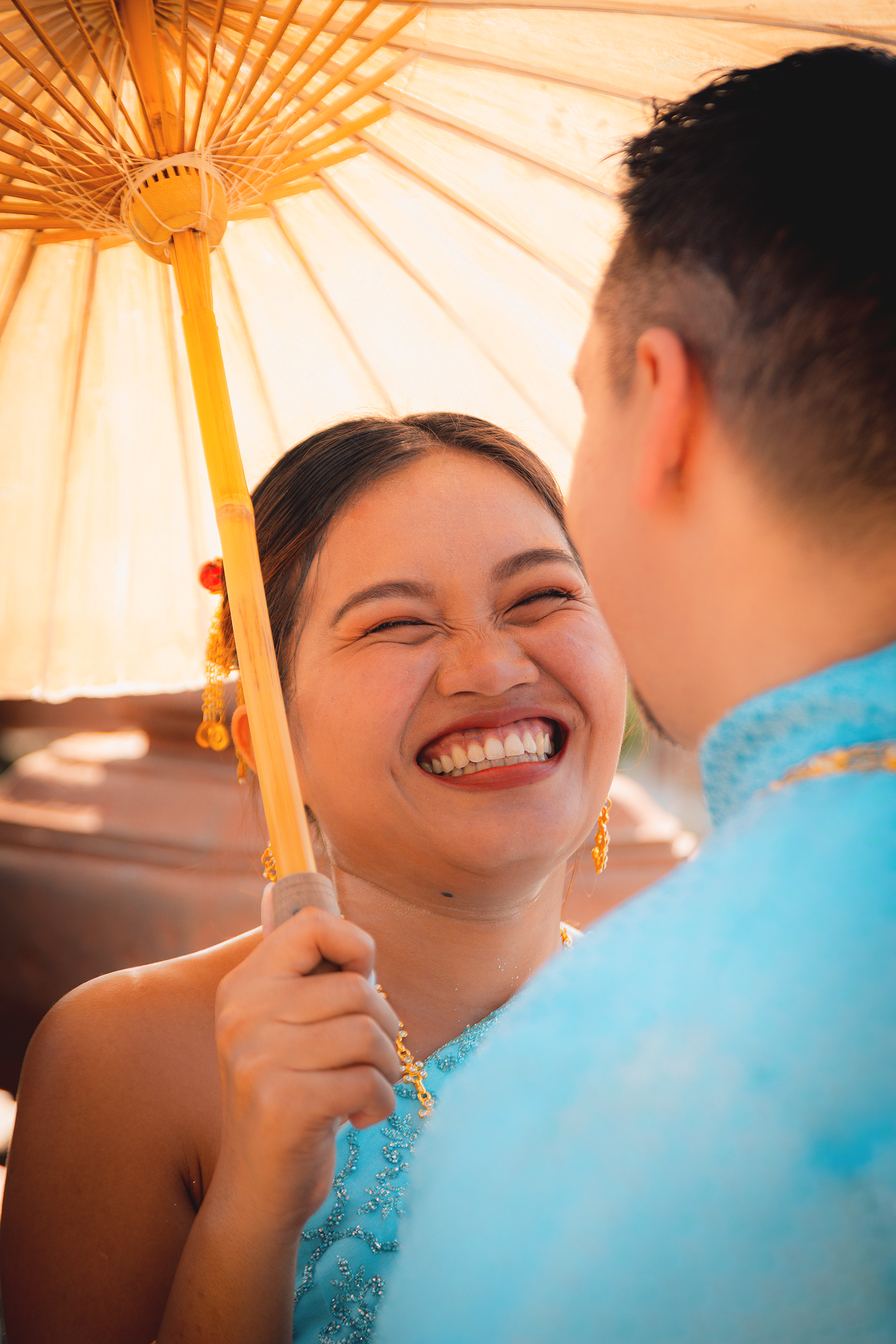 Engagement photography featuring a smiling couple sharing a candid moment during a proposal session in Bangkok.