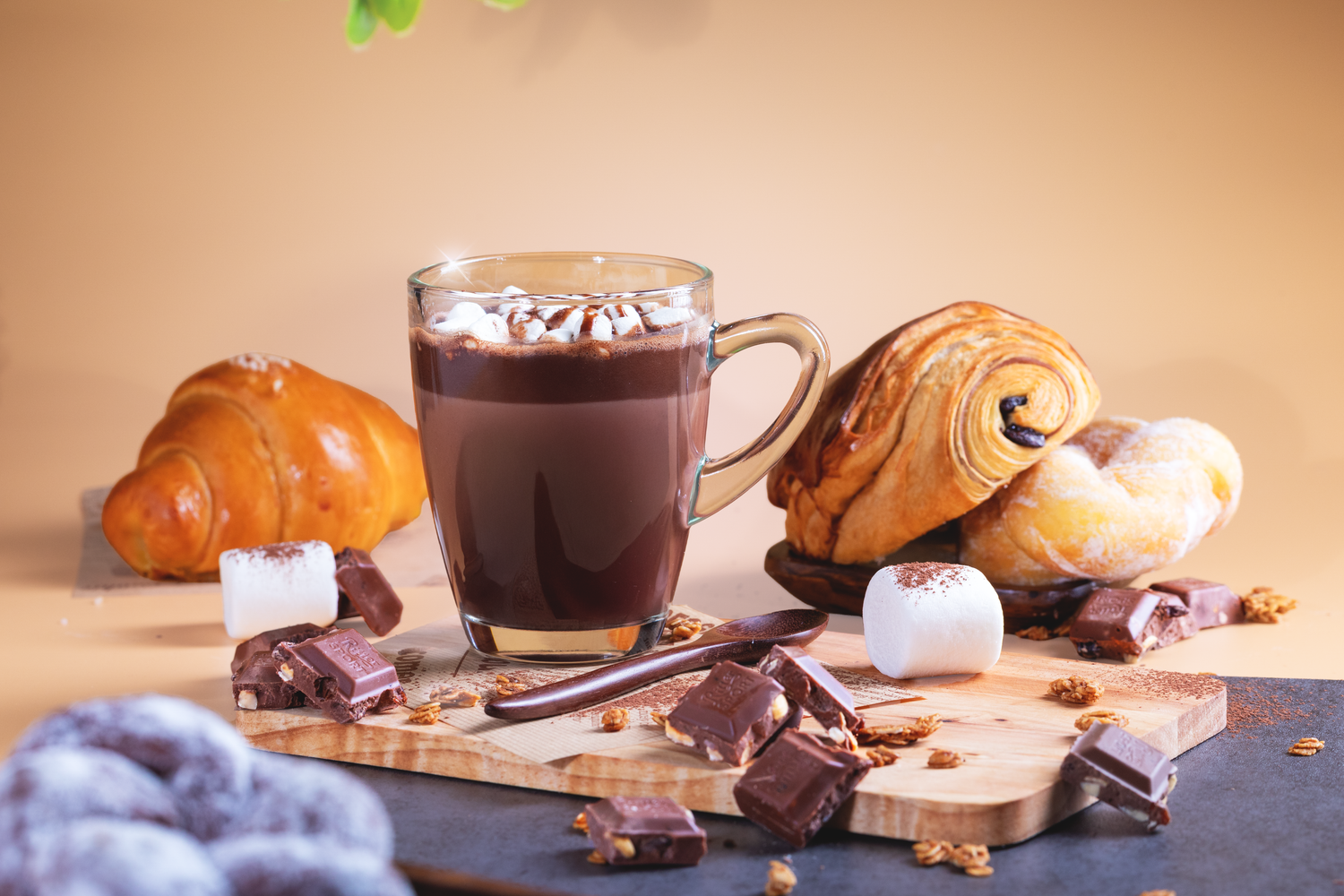 Commercial café photography featuring hot chocolate, croissants, and baked goods styled for restaurant advertising and social media.