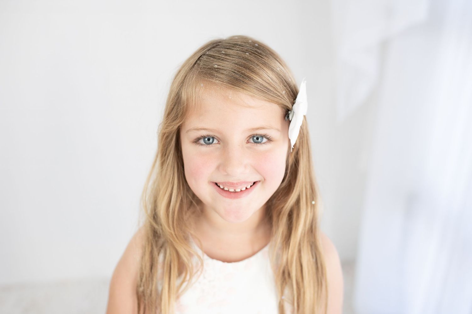 Portrait session against white backdrop with soft natural lighting.