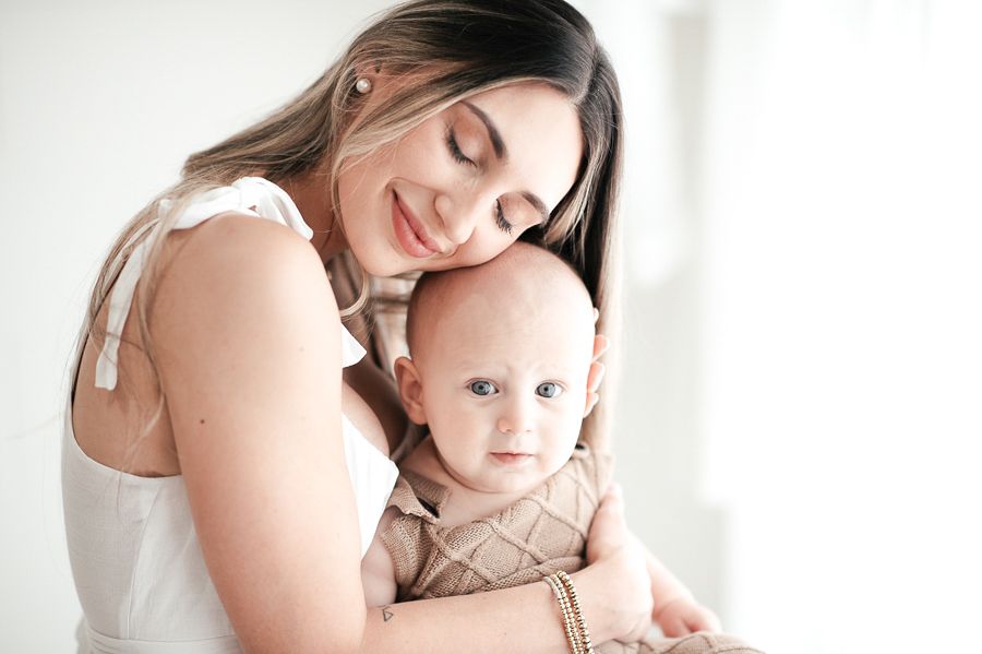 Tender family moment captured during white-themed portrait session.