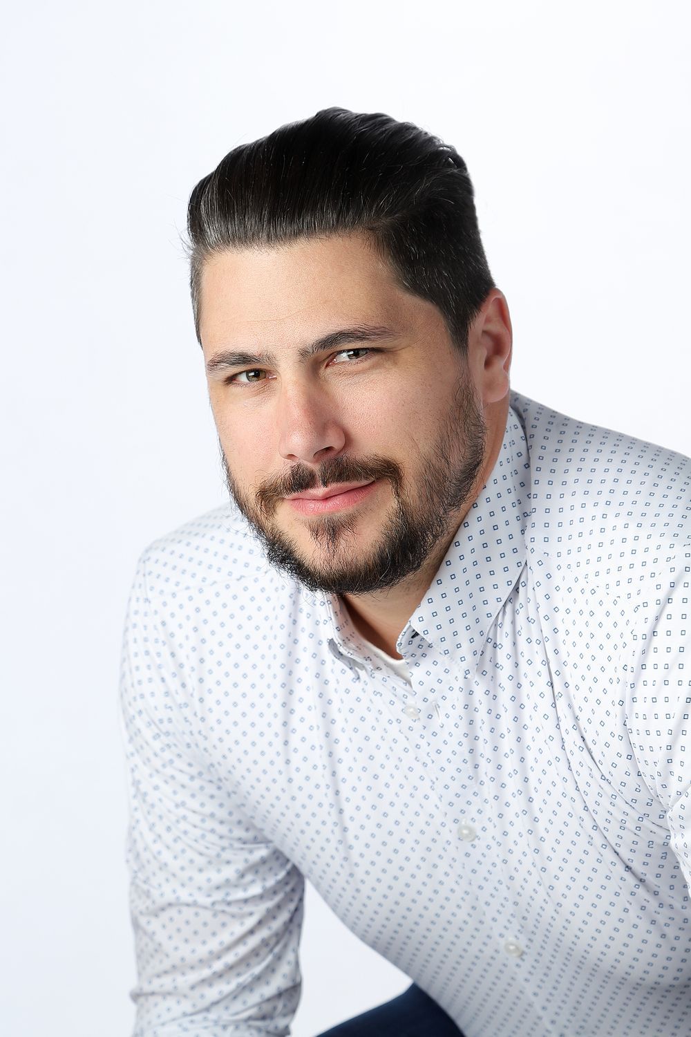 Professional headshots of person in white polka dot shirt against white background.