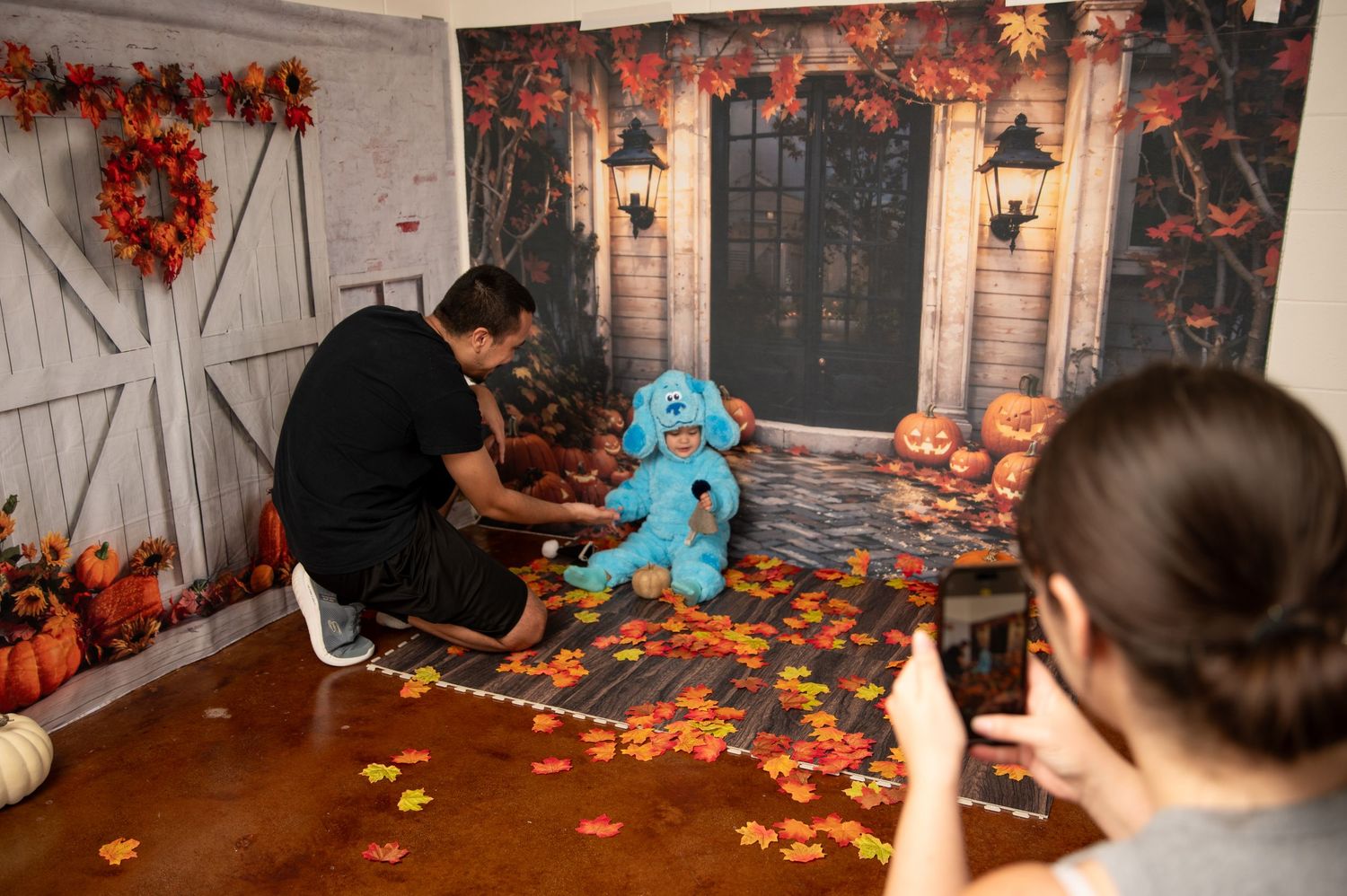 Halloween themed photo set with fall decorations and spooky barn door backdrop.