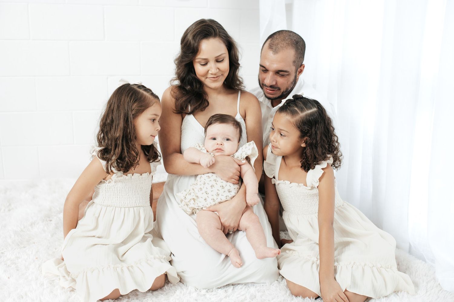 Intimate family portrait session with everyone dressed in matching white attire.