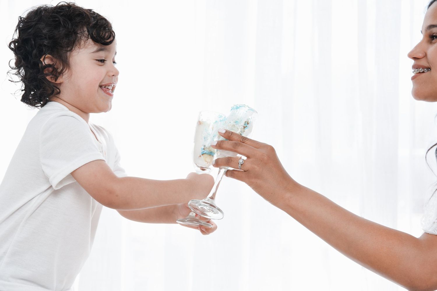 A series of four connected photos showing a parent feeding a baby in a white outfit against a bright background.