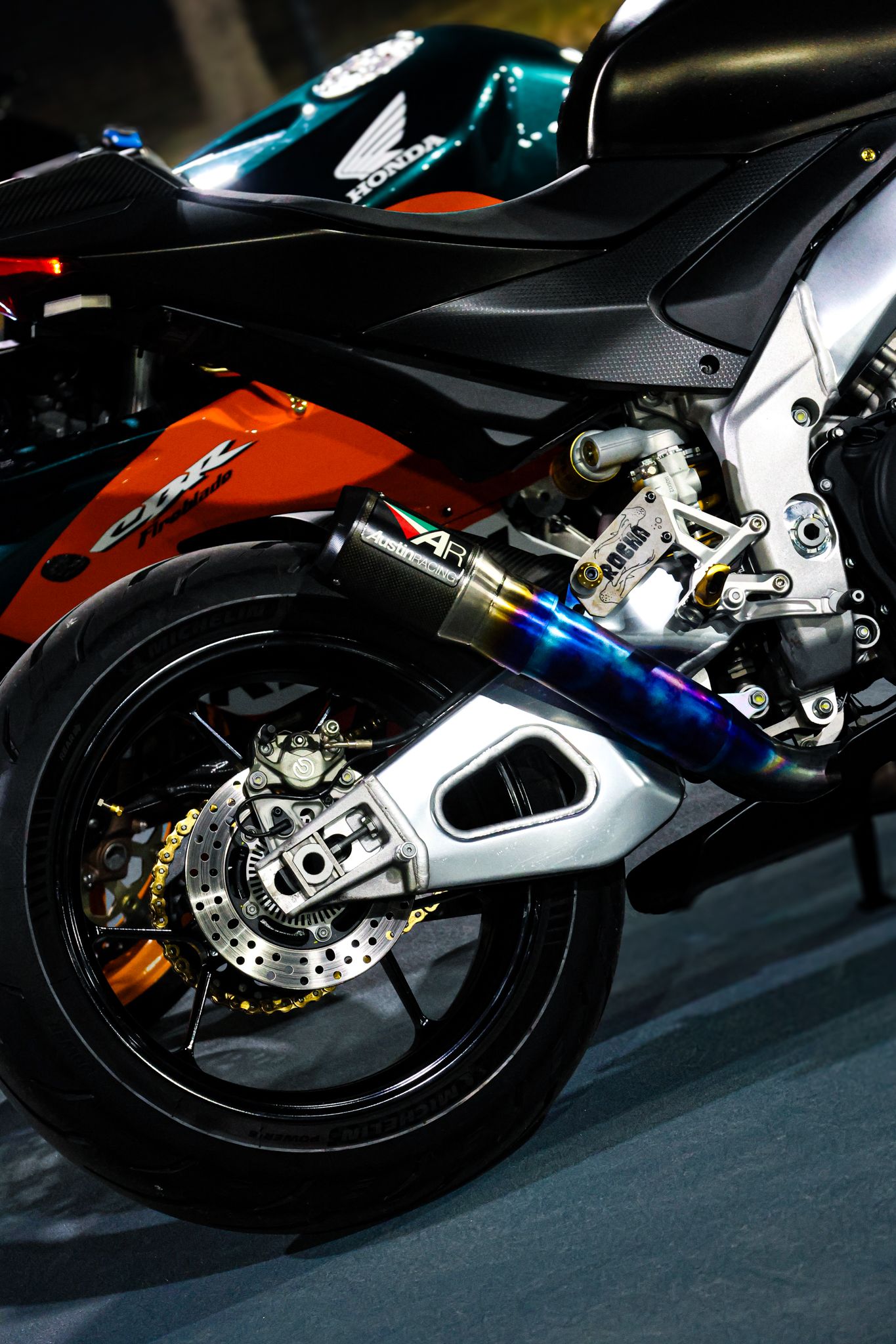 Close-up details of a black and silver sports motorcycle showing the rear wheel assembly and suspension.