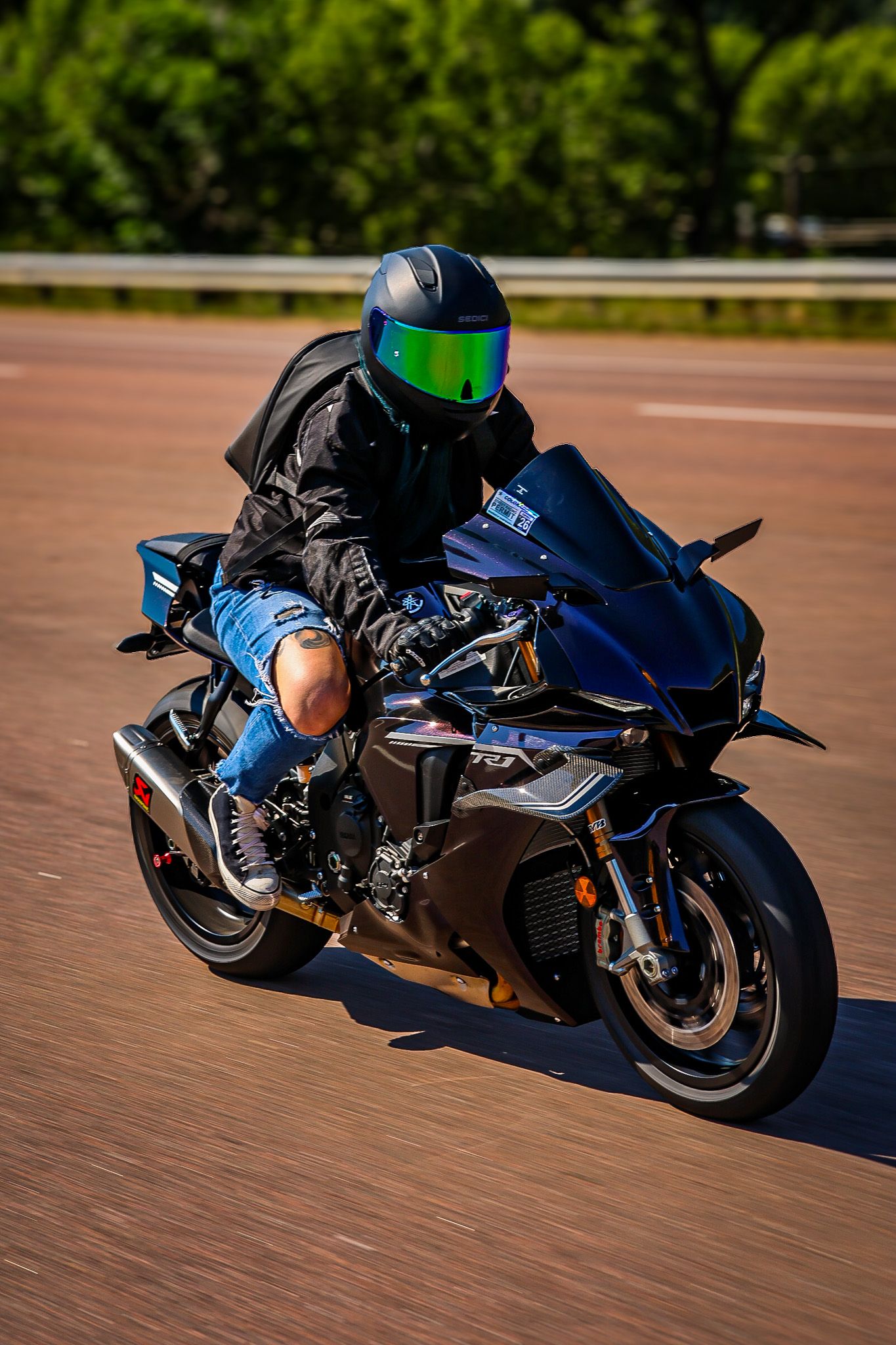 A sequence of action shots showing a motorcycle rider leaning into turns on a blue sportbike at a racetrack.