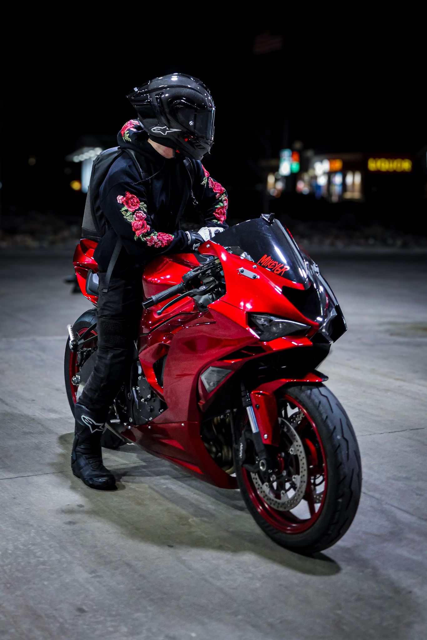 Red sports motorcycle photographed from multiple angles on dark concrete floor with dramatic lighting.