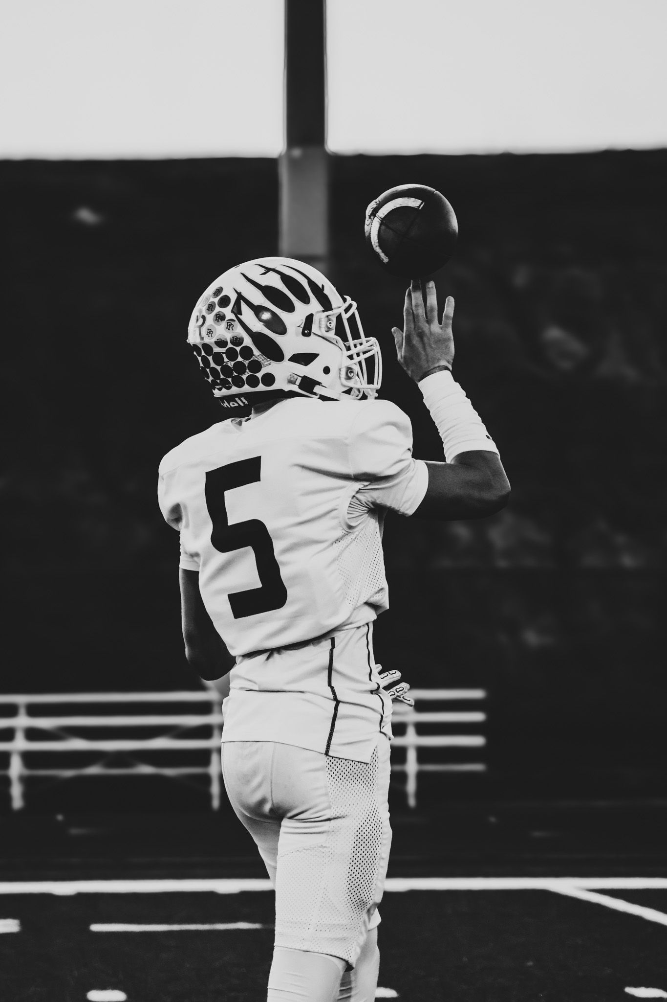 Football player in white uniform celebrates by jumping and hugging teammate after scoring touchdown.