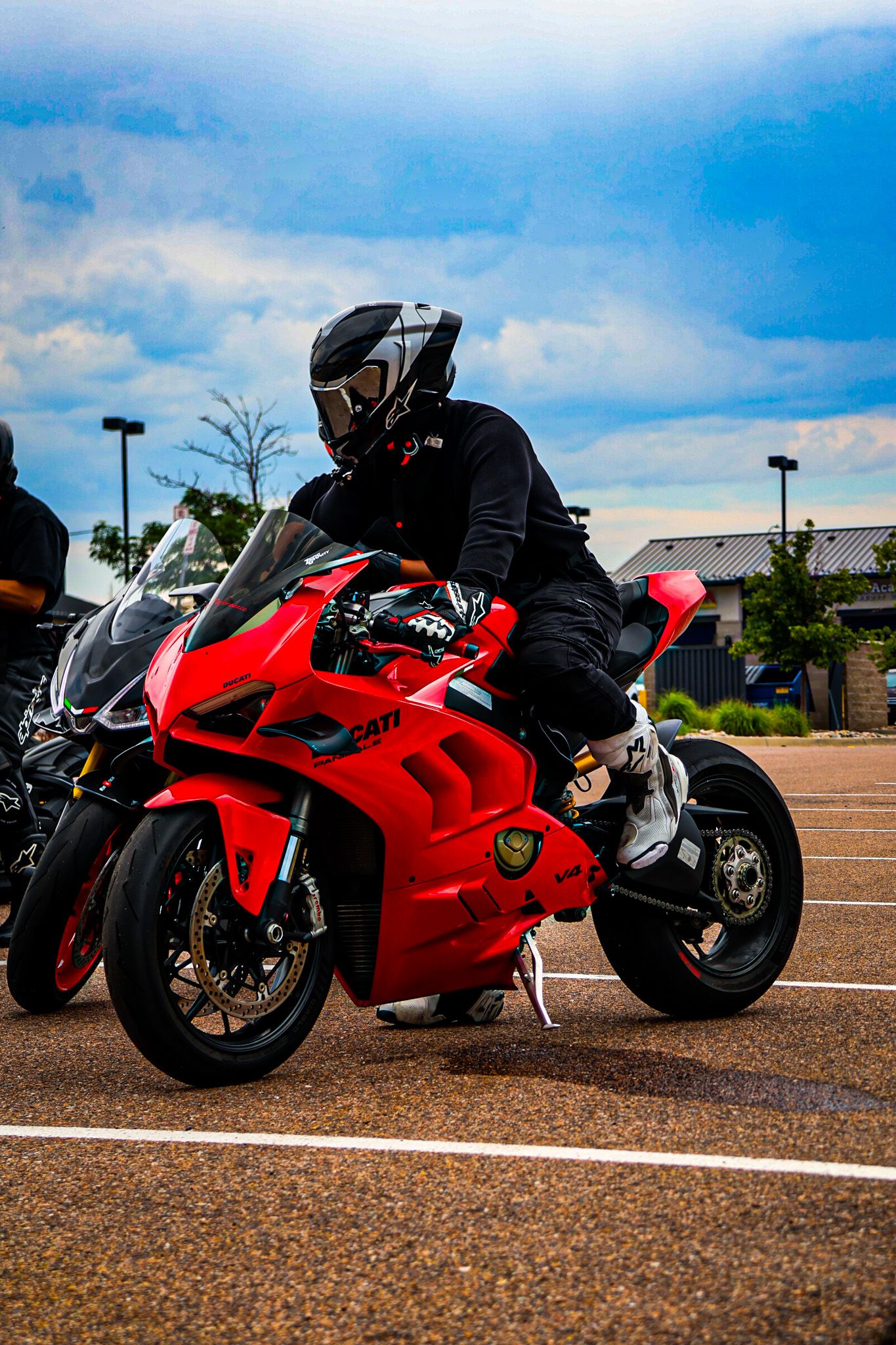 A series of shots showing a red sportbike motorcycle from different angles in a parking lot under blue skies.