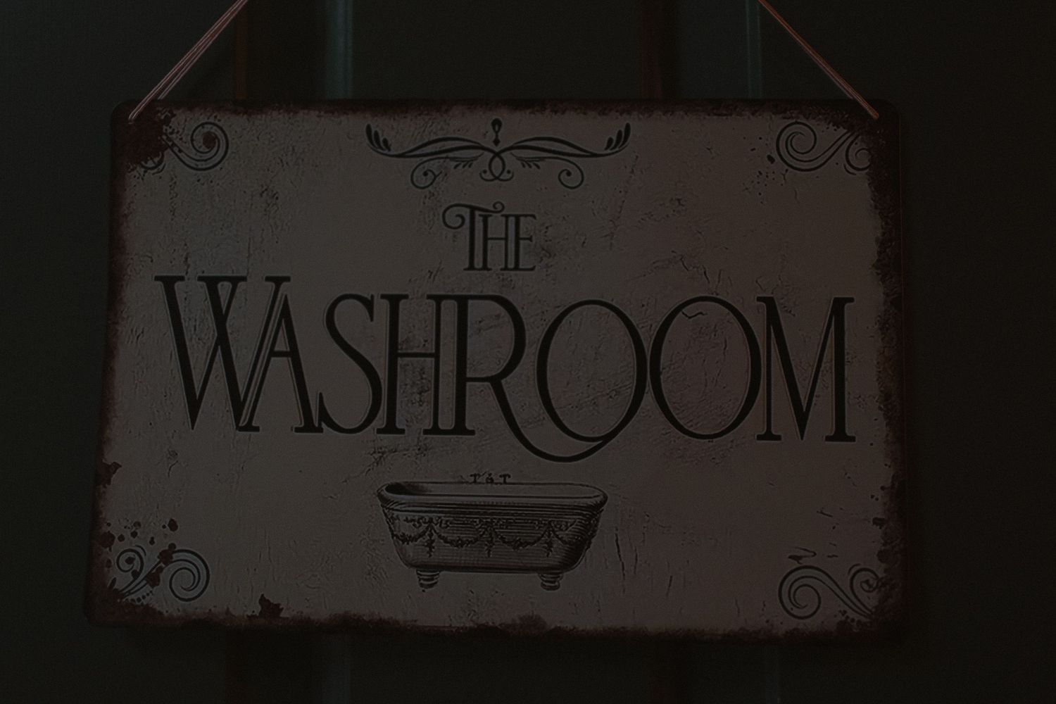 Vintage-style decorative bathroom sign with ornate lettering and bathtub illustration.