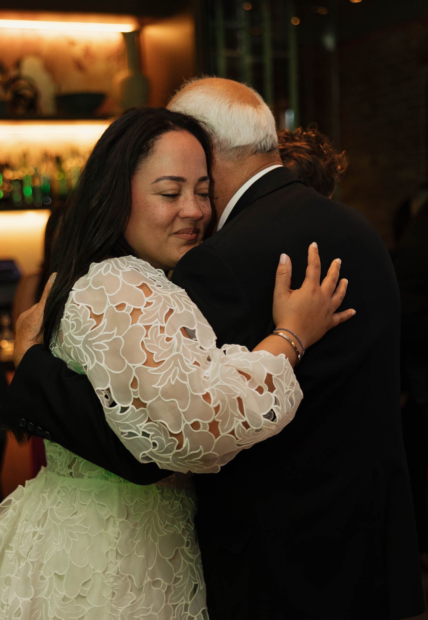 Warm-lit wedding dance photos showing tender moments between newlyweds in an indoor venue.