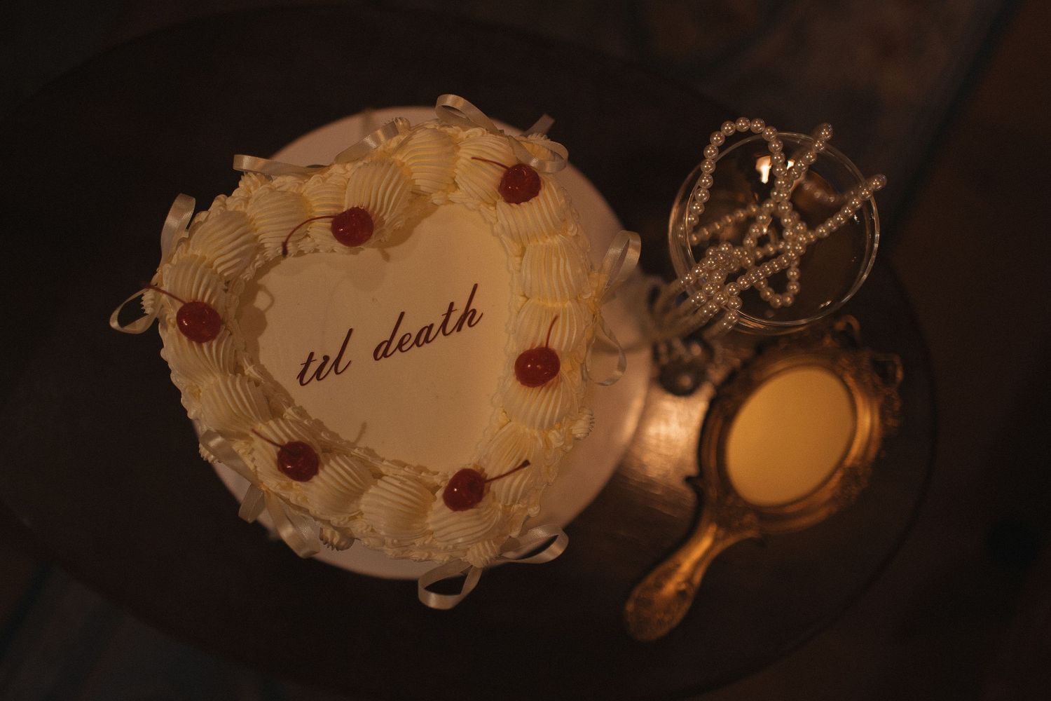 Antique paper cards and decorative items illuminated by candlelight.